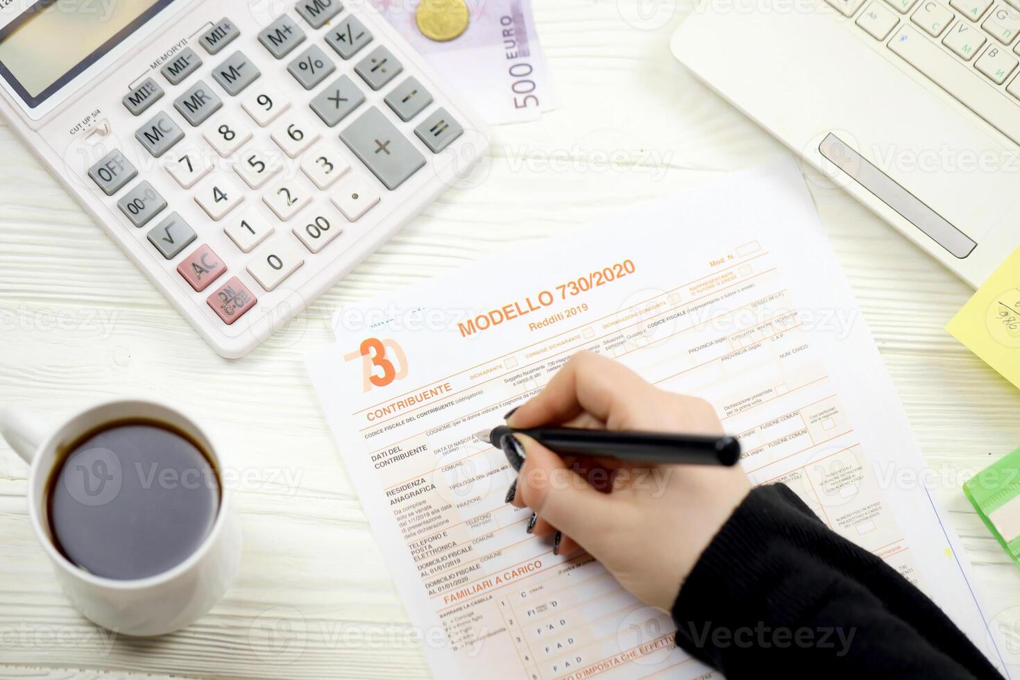 Accountant fill italian tax form Modello 730 individual income tax return in end of tax period. Taxation and paperwork routine photo