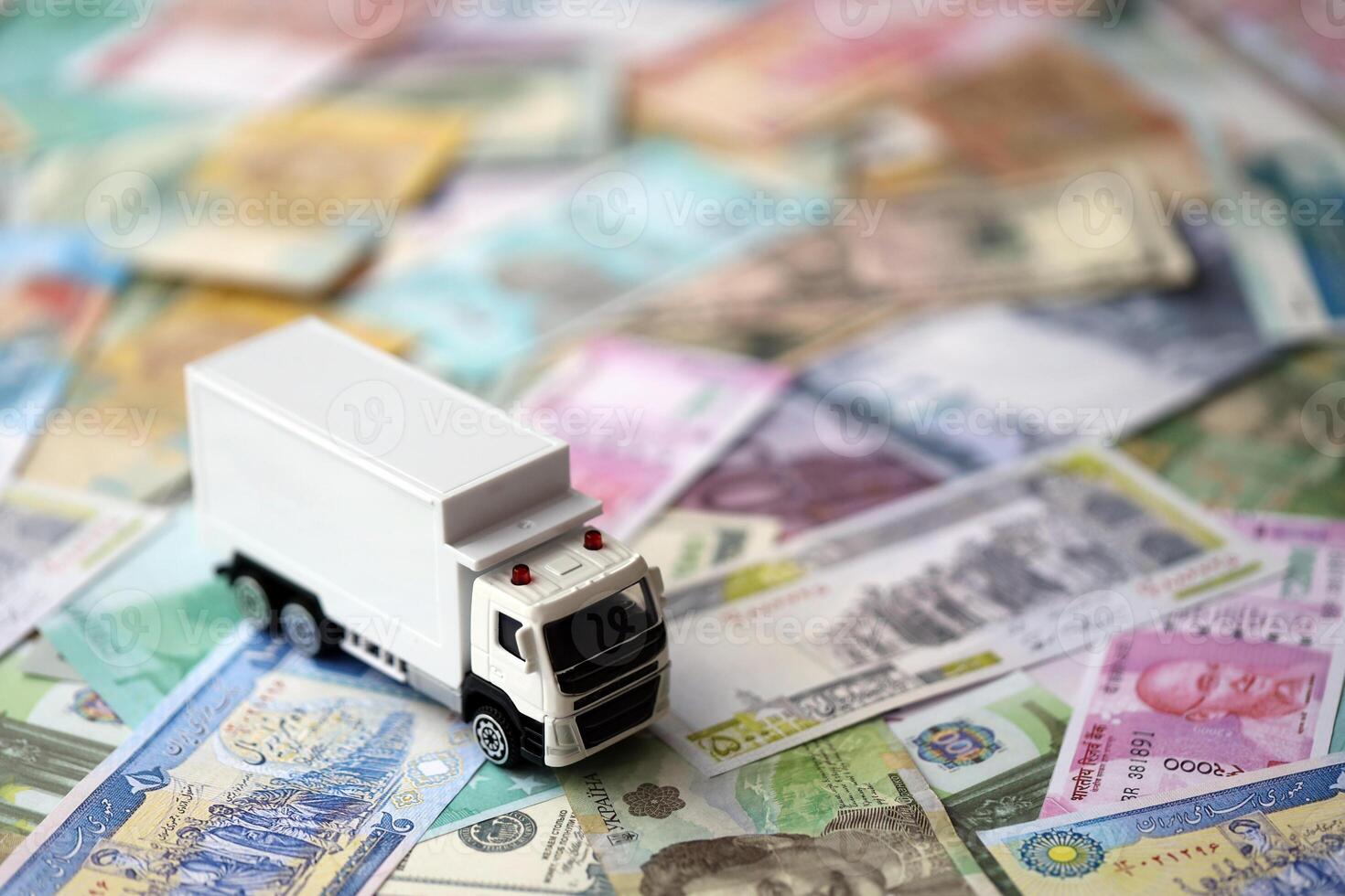 Delivery truck on many banknotes of different currency. Background of trucking or moving concept photo
