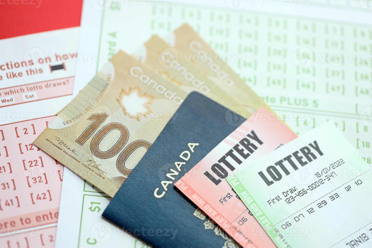 Lottery tickets lies with canadian dollars on gambling sheets with numbers for marking to play lottery photo