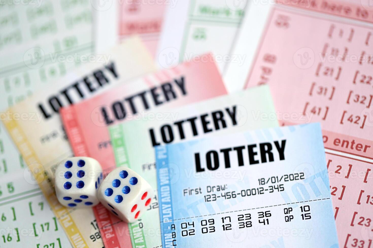 Lottery tickets of different colors and dice on blank bills with numbers for playing lottery photo