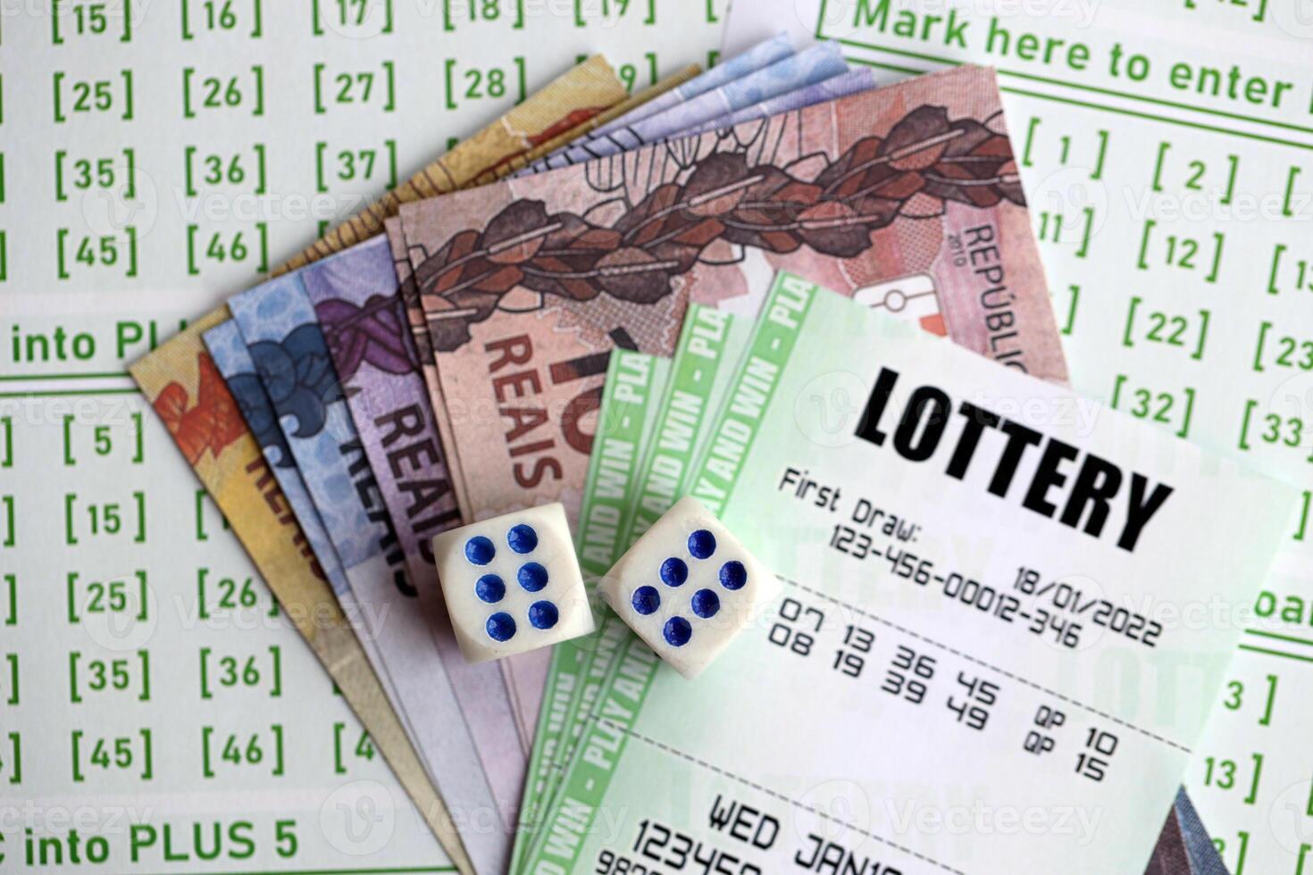 Green lottery tickets and brazilian reals money bills on blank with numbers for playing lottery photo