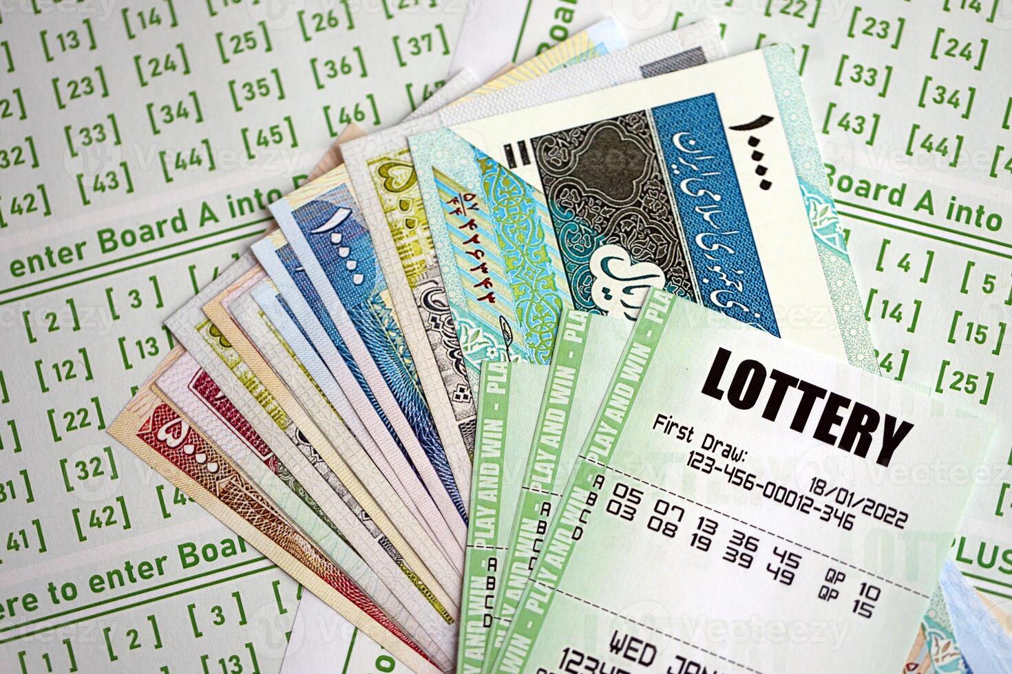 Green lottery tickets and iranian money bills on blank with numbers for playing lottery photo