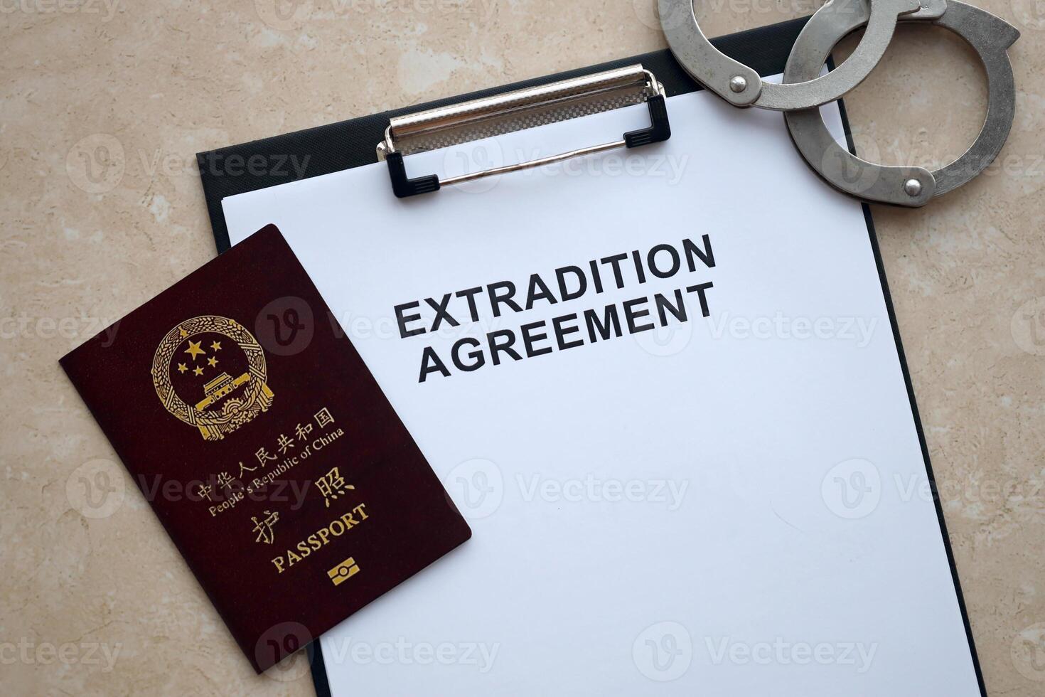 Passport of China Republic and Extradition Agreement with handcuffs on table photo