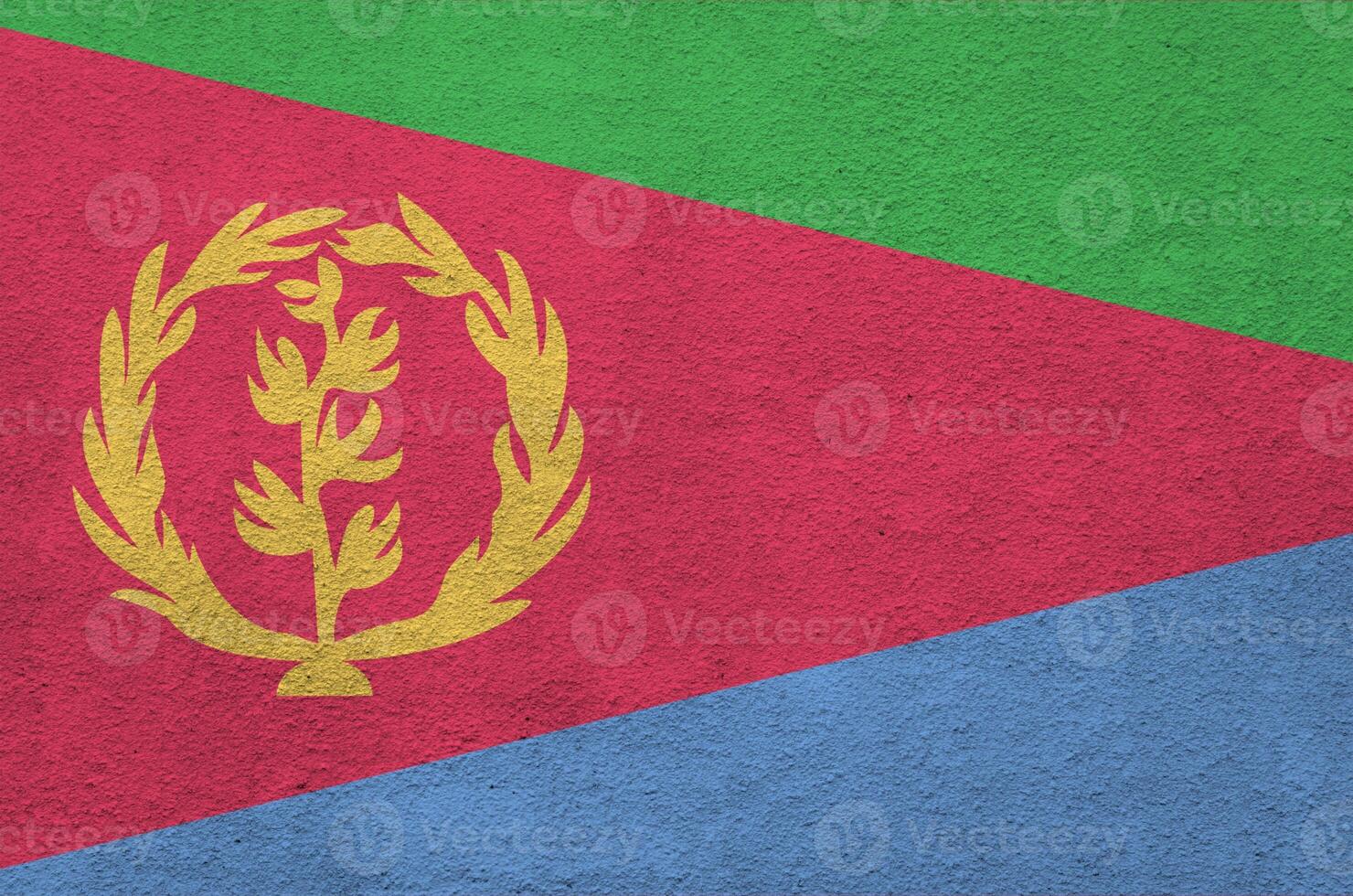 Eritrea flag depicted in bright paint colors on old relief plastering wall. Textured banner on rough background photo