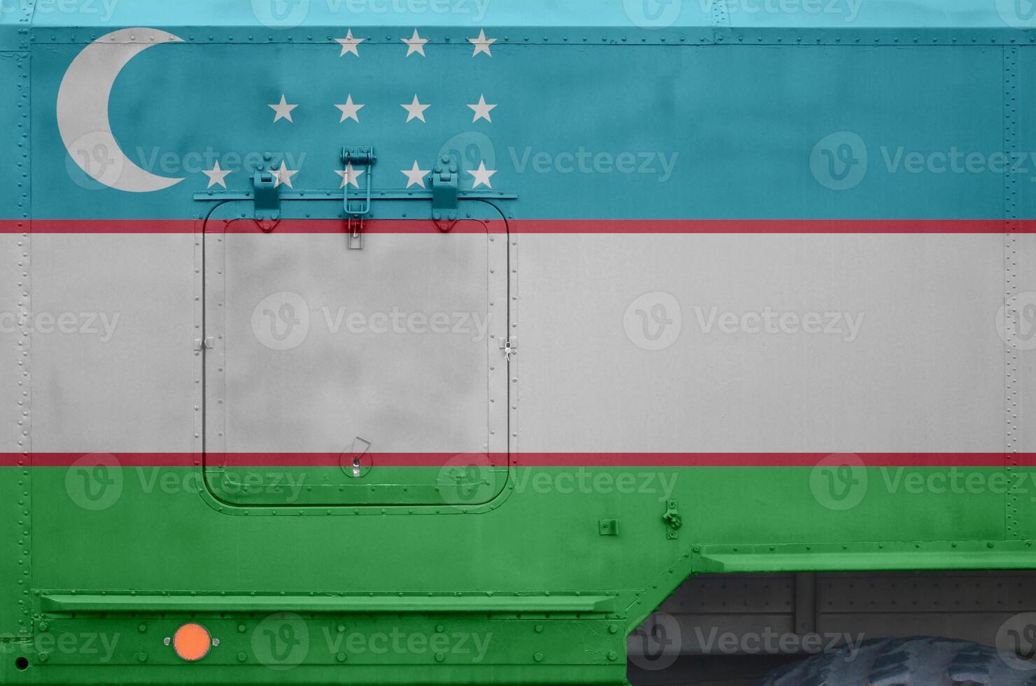 Uzbekistan flag depicted on side part of military armored truck closeup. Army forces conceptual background photo