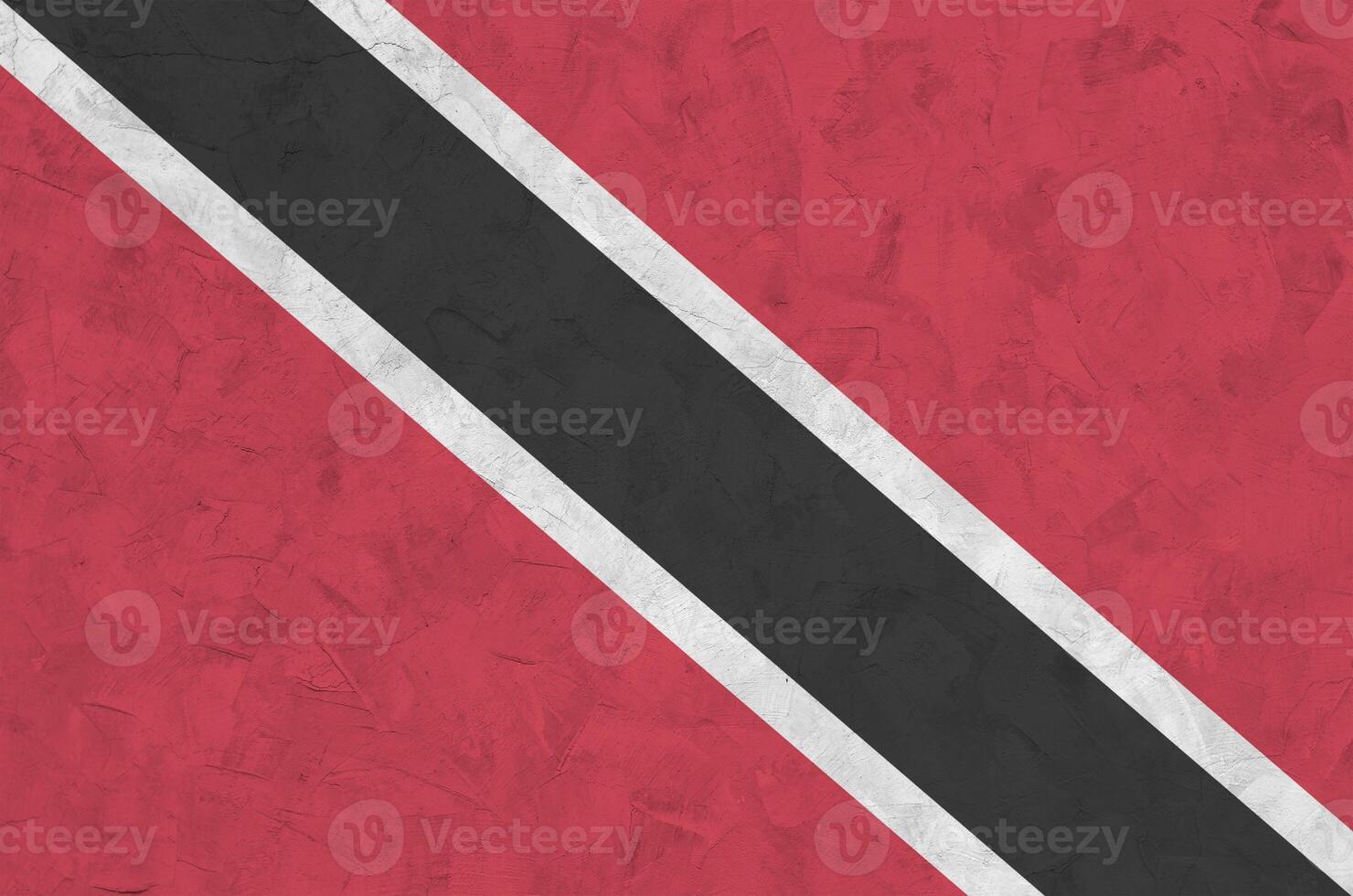 Trinidad and Tobago flag depicted in bright paint colors on old relief plastering wall. Textured banner on rough background photo