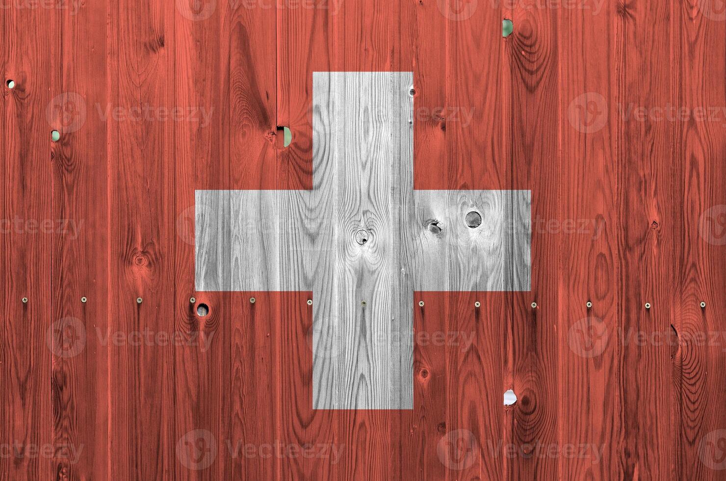 Switzerland flag depicted in bright paint colors on old wooden wall. Textured banner on rough background photo