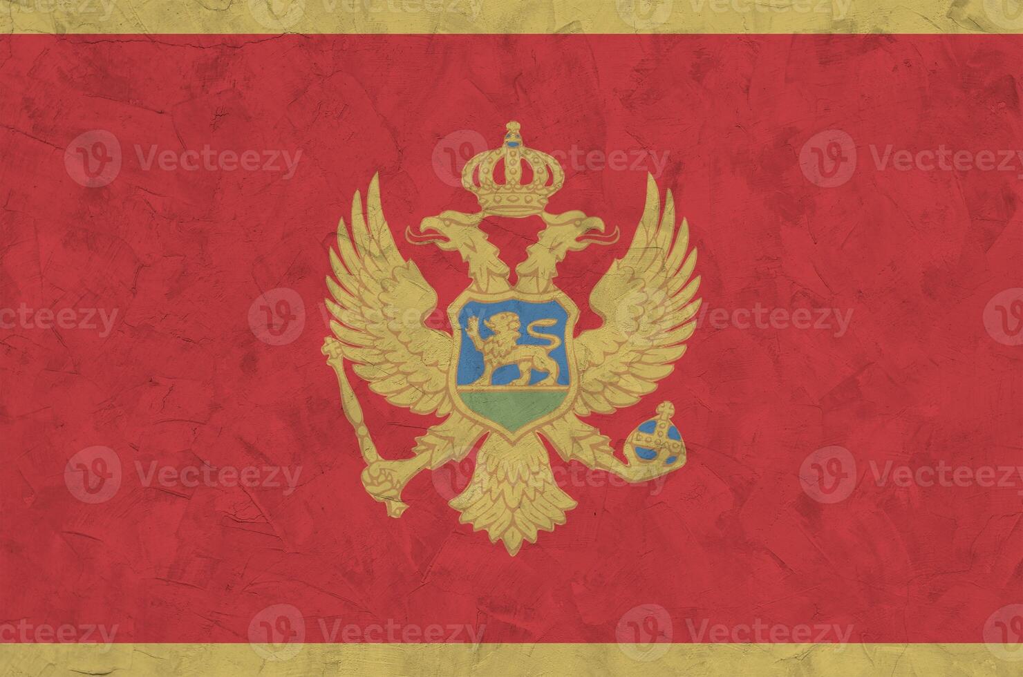 Montenegro flag depicted in bright paint colors on old relief plastering wall. Textured banner on rough background photo