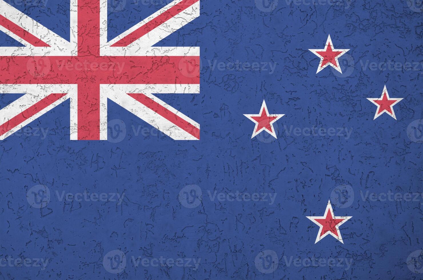 New Zealand flag depicted in bright paint colors on old relief plastering wall. Textured banner on rough background photo