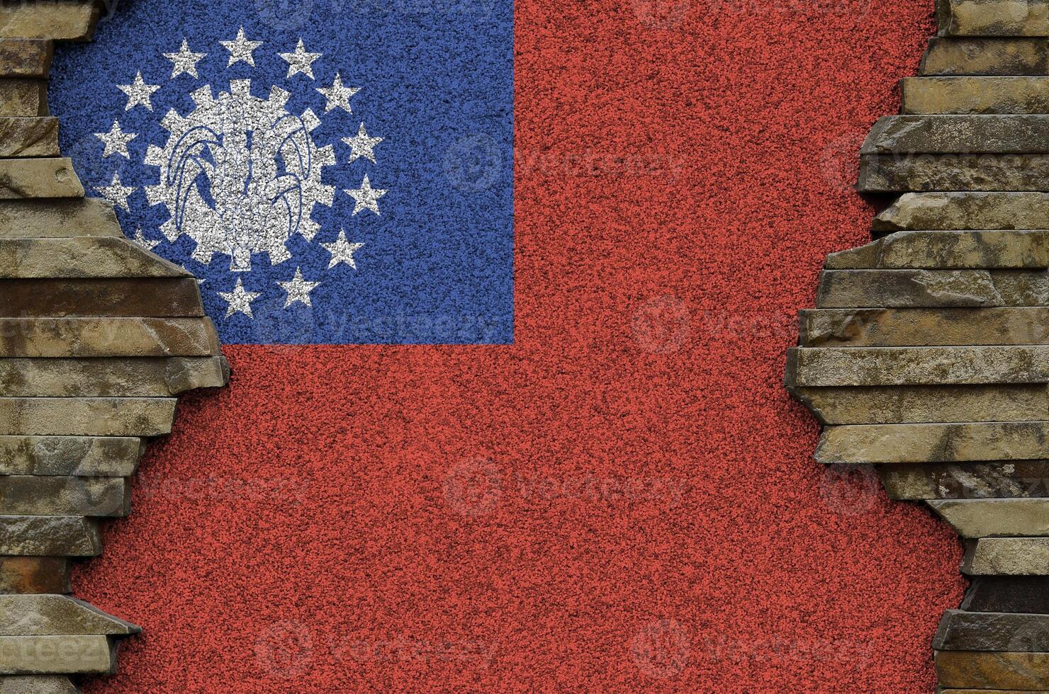 Myanmar flag depicted in paint colors on old stone wall closeup. Textured banner on rock wall background photo