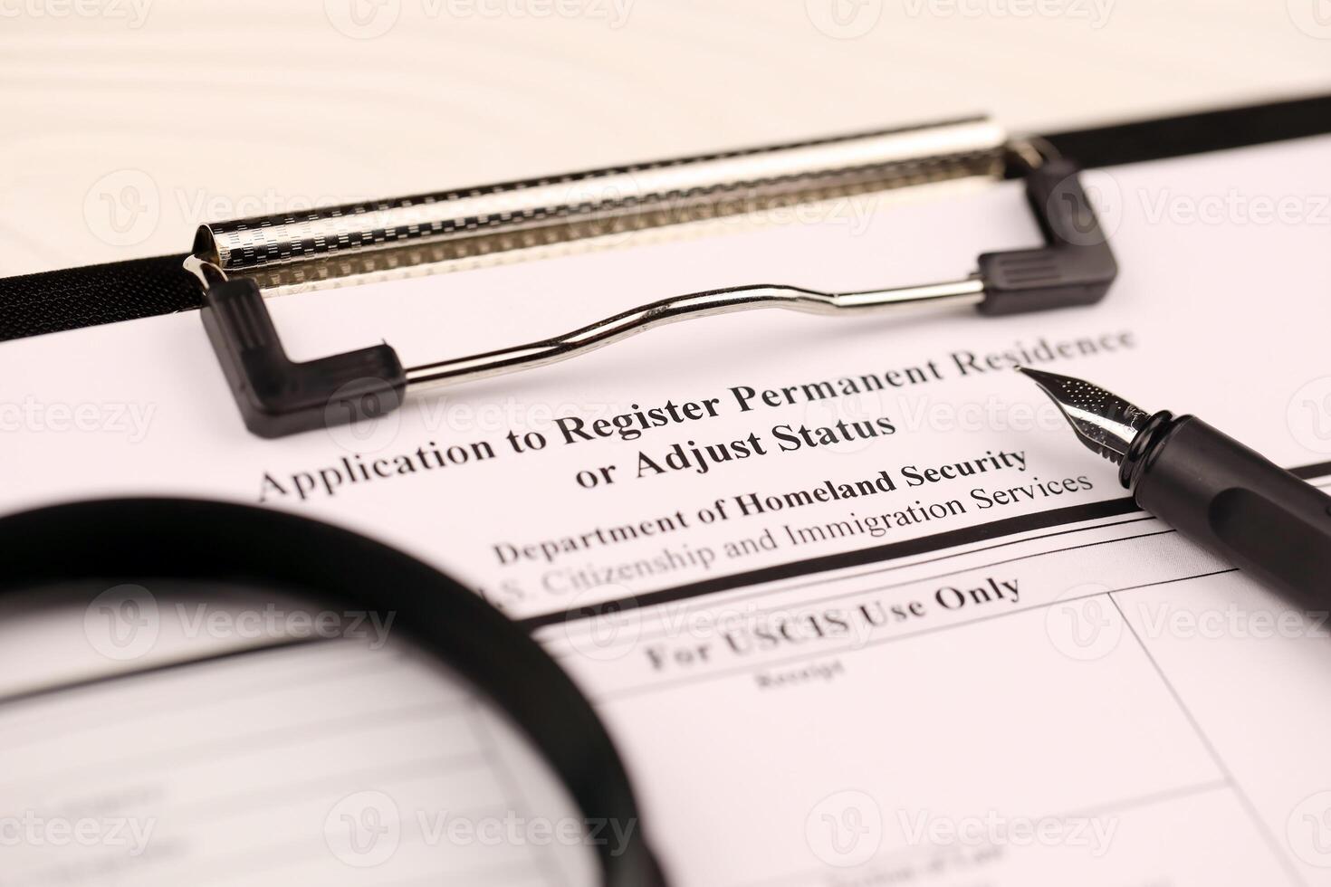 I-485 Application to register permanent residence or adjust status blank form on A4 tablet lies on office table with pen and magnifying glass photo