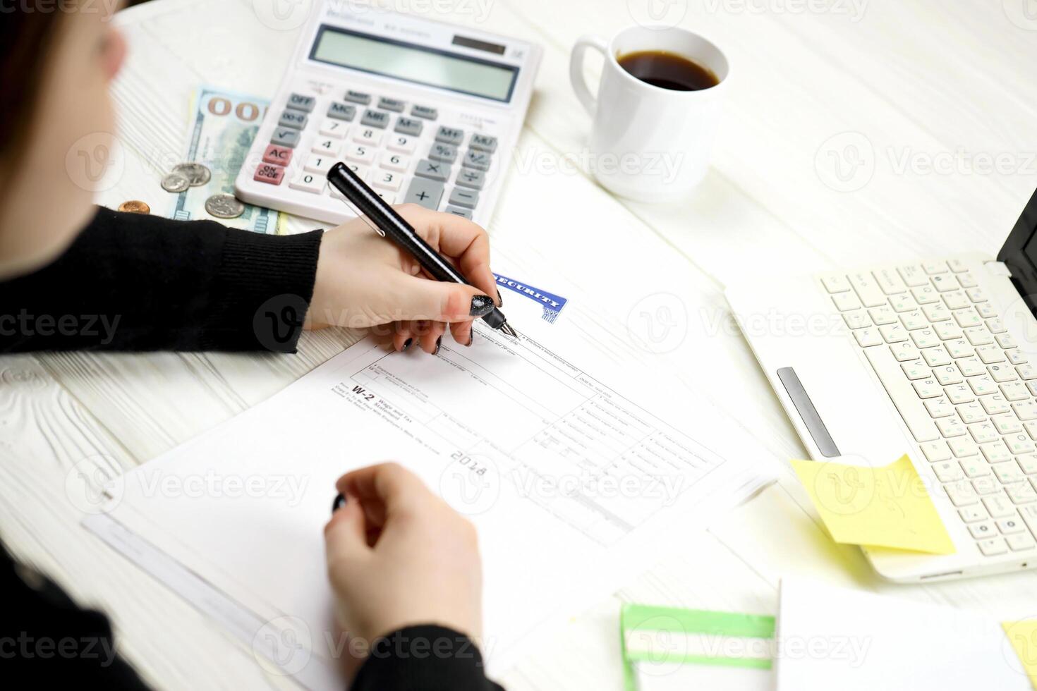 Accountant fill American tax form W-2 Wage and Tax Statement in end of tax period. Taxation and paperwork routine photo