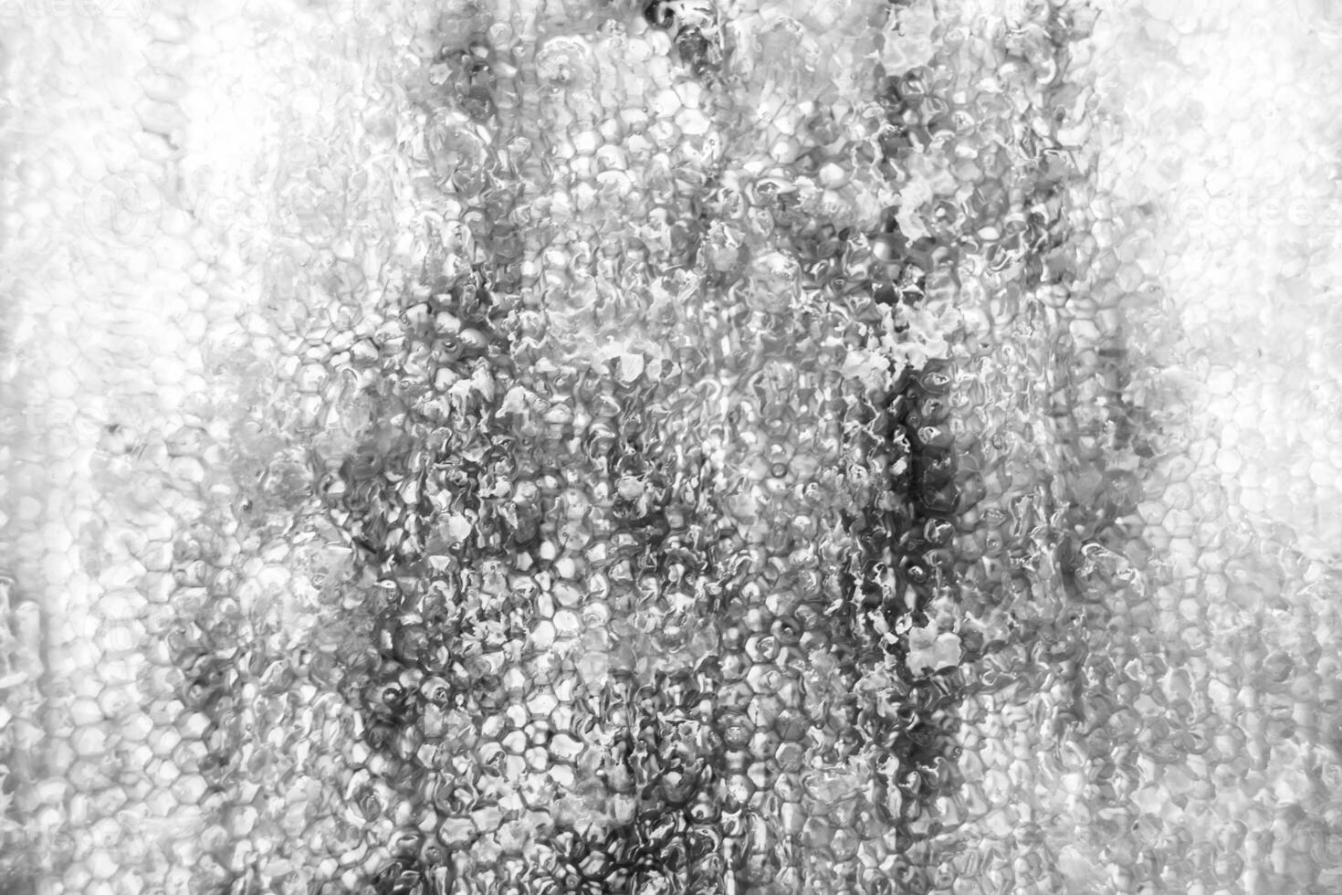 Drop of bee honey drip from hexagonal honeycombs filled with golden nectar photo