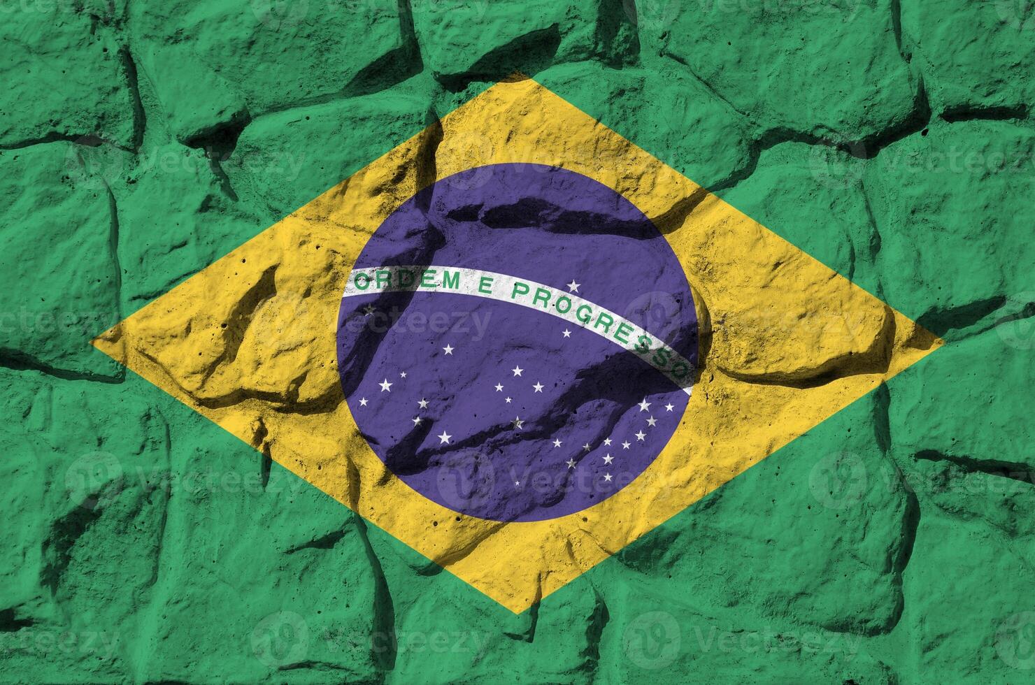 Brazil flag depicted in paint colors on old stone wall closeup. Textured banner on rock wall background photo
