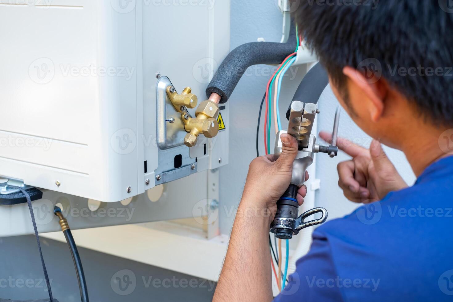 Male technician installing outdoor unit of air conditioner to cool the household in the summer. air compressor, electronic, photo