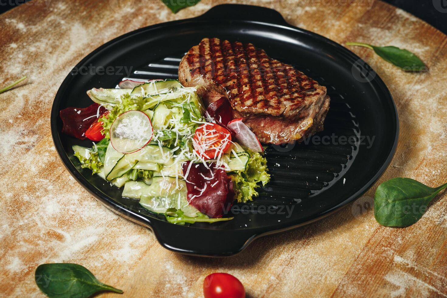 Grilled Steak Served With Fresh Garden Salad on a Black Plate photo