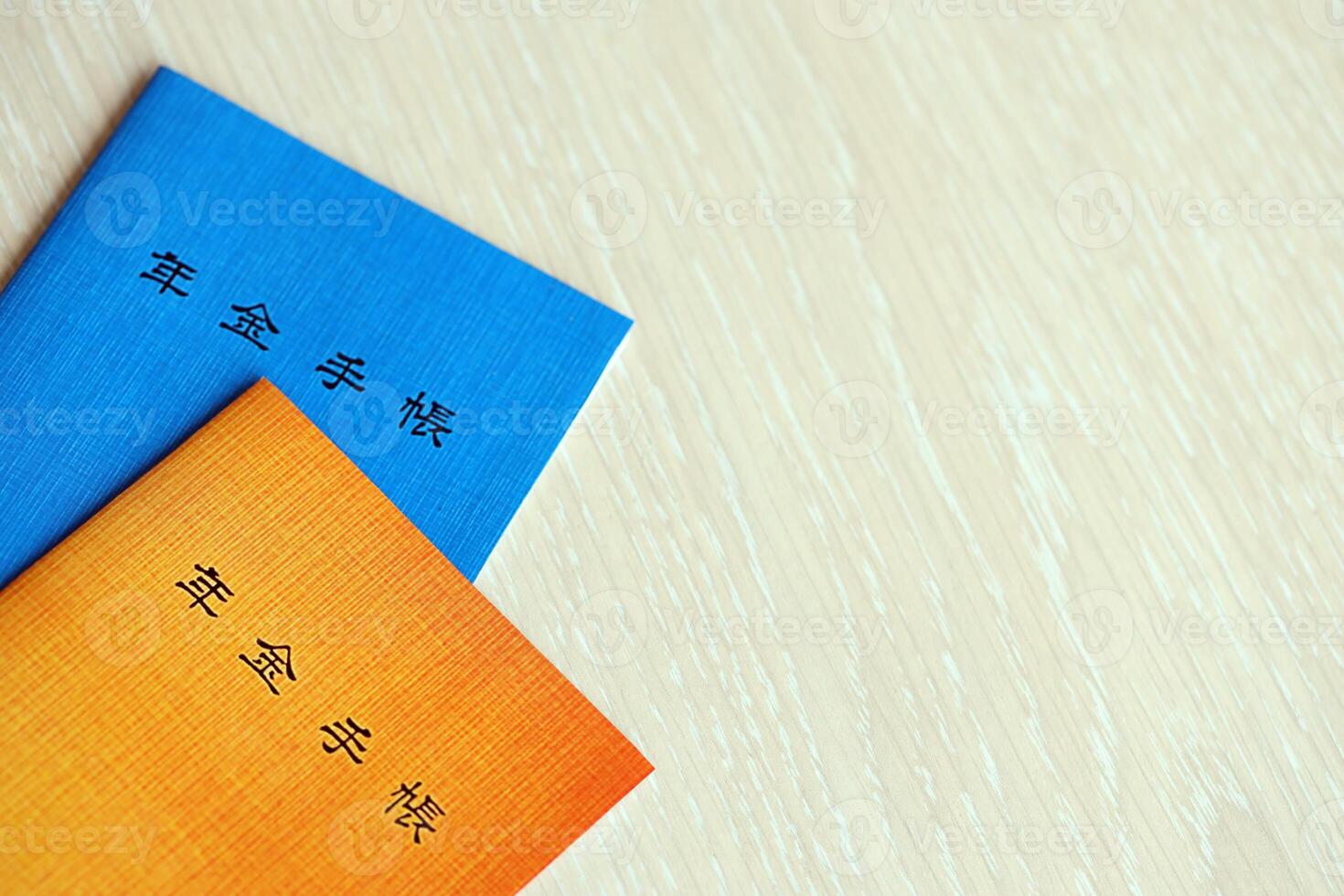 Japanese pension insurance booklets on table. Blue and orange pension book for japan photo