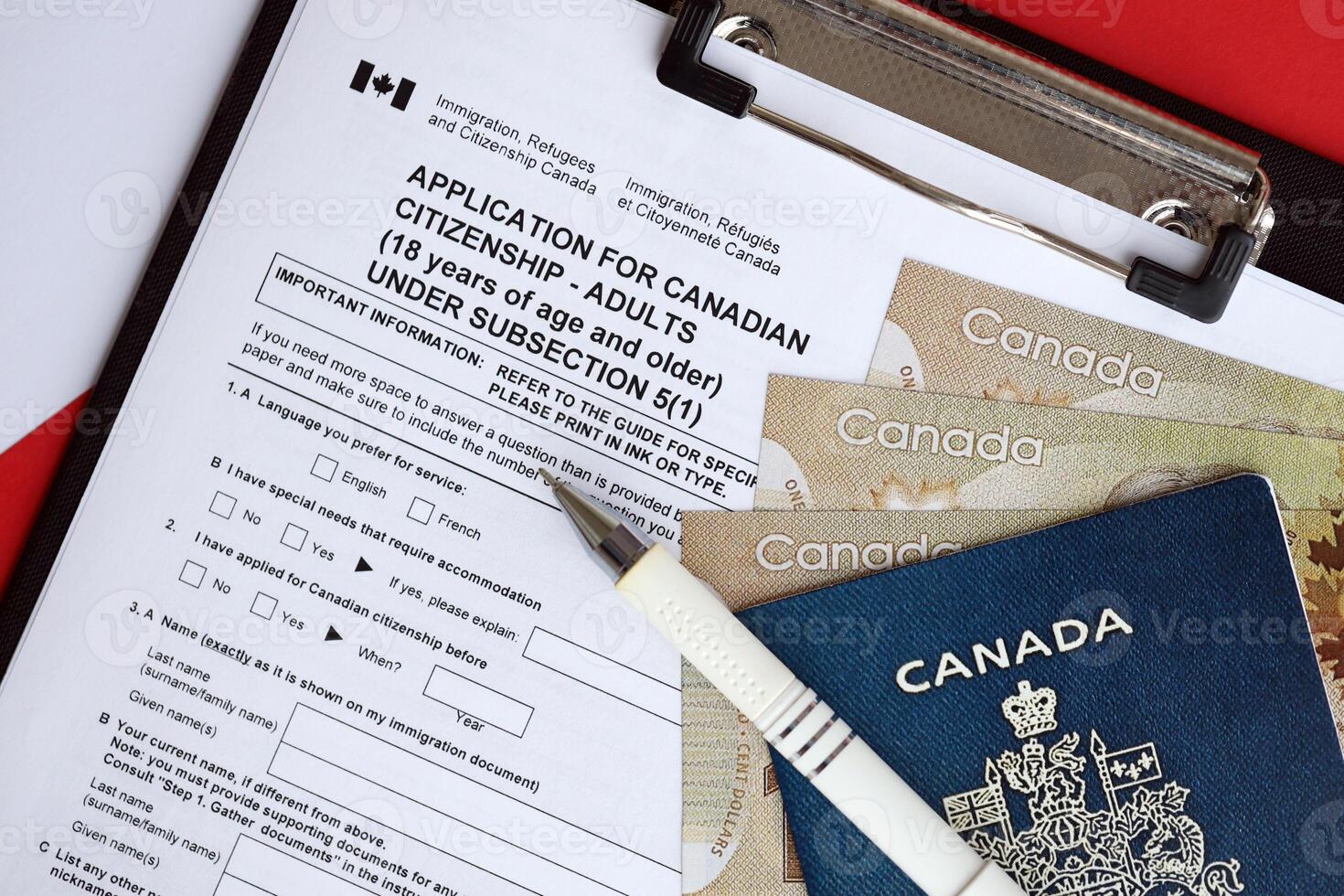 Application for Canadian citizenship for adults on table with pen, passport and dollar bills photo
