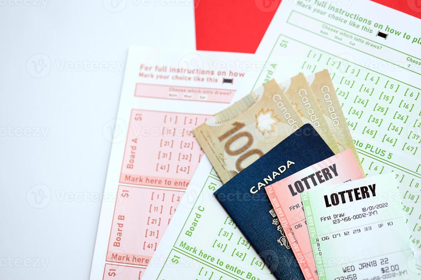 Lottery tickets lies with canadian dollars on gambling sheets with numbers for marking to play lottery photo