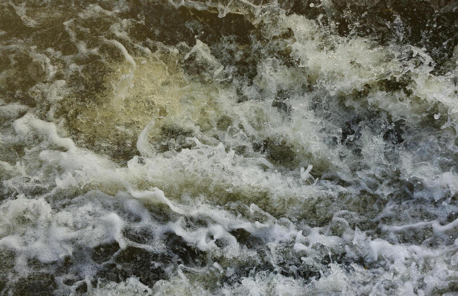 Waves of water of the river and the sea meet each other during high tide and low tide. Deep blue stormy sea water surface with white foam and waves pattern, background photo