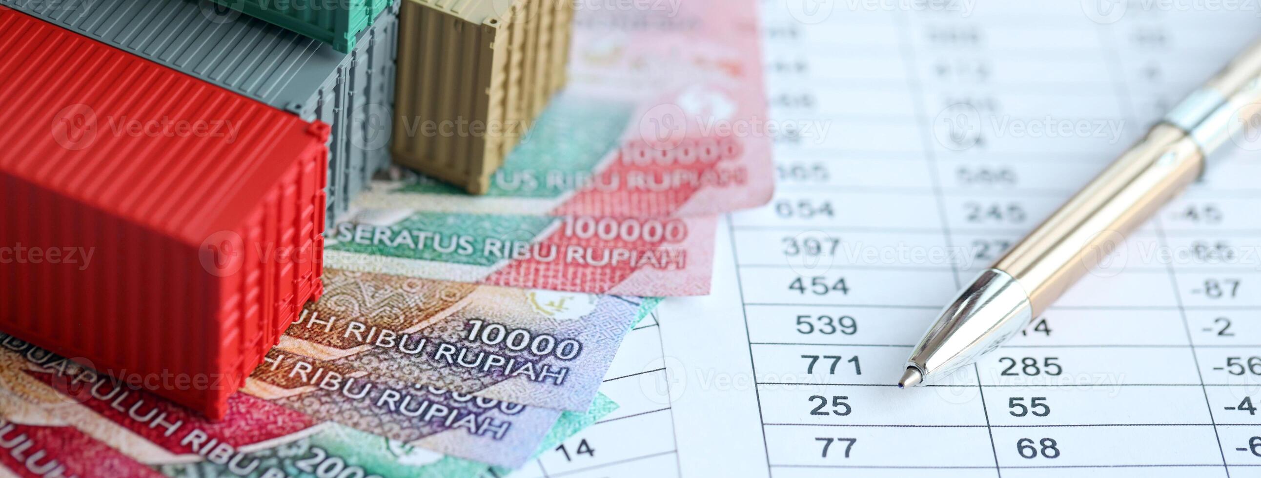 Company shipping cargo containers in Indonesia with rupiah money bills and pen photo