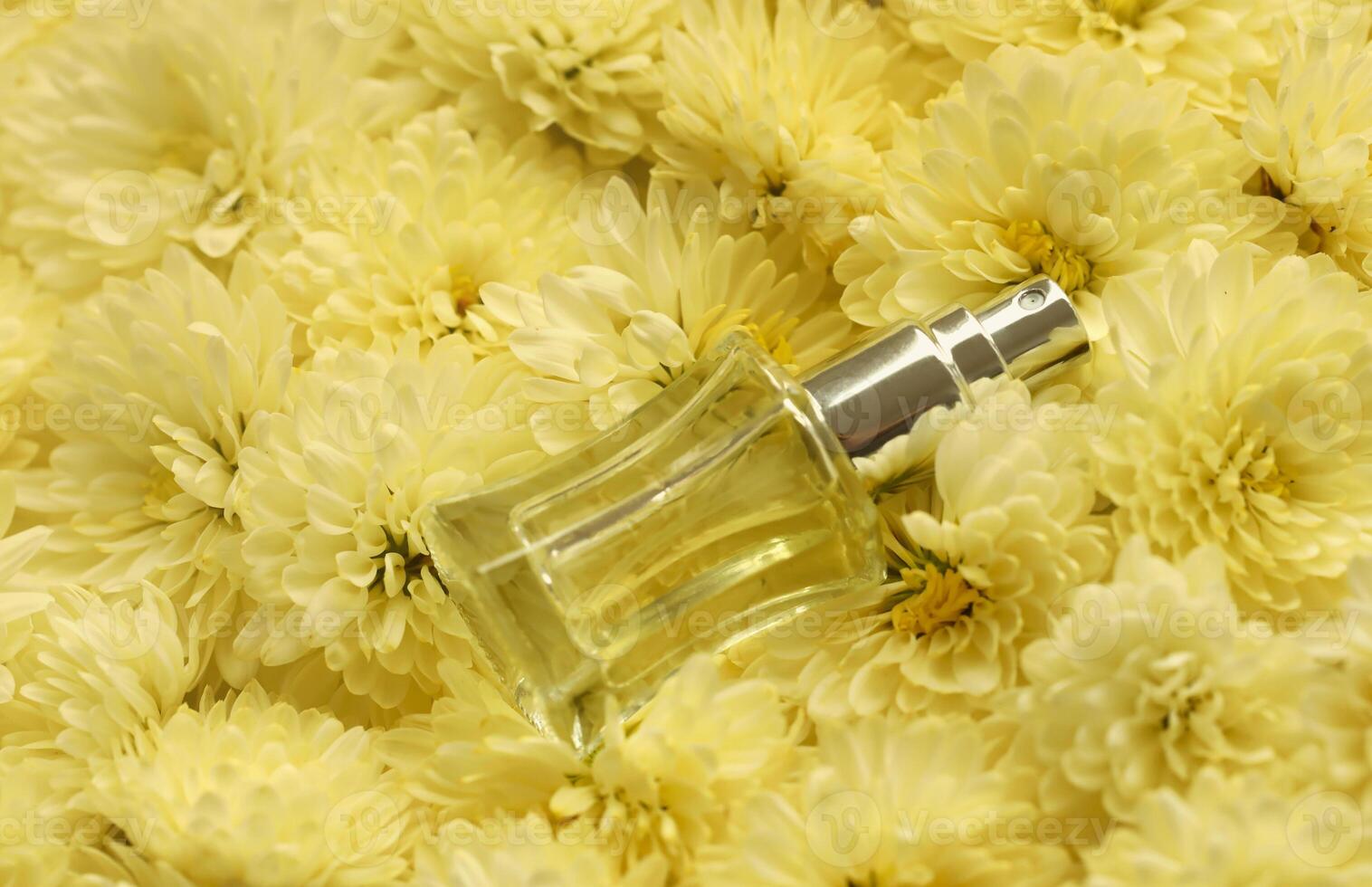 Women fragrance perfume bottle with flowers background close up. Unnamed blank sprayer bottle of perfume photo