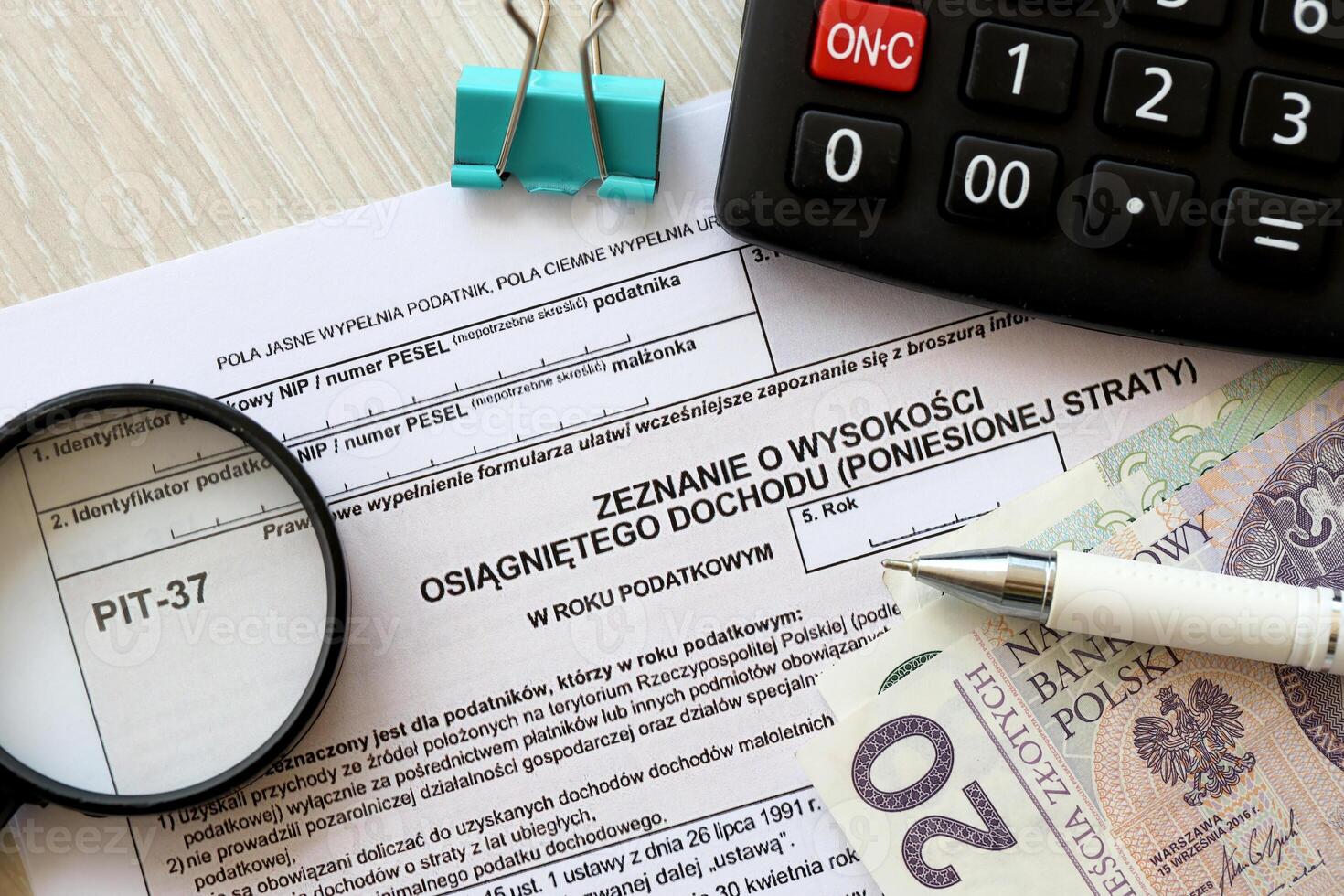 Declaration of the amount of earned income or incurred loss PIT-37 tax forms on accountant table with pen and polish zloty money bills photo