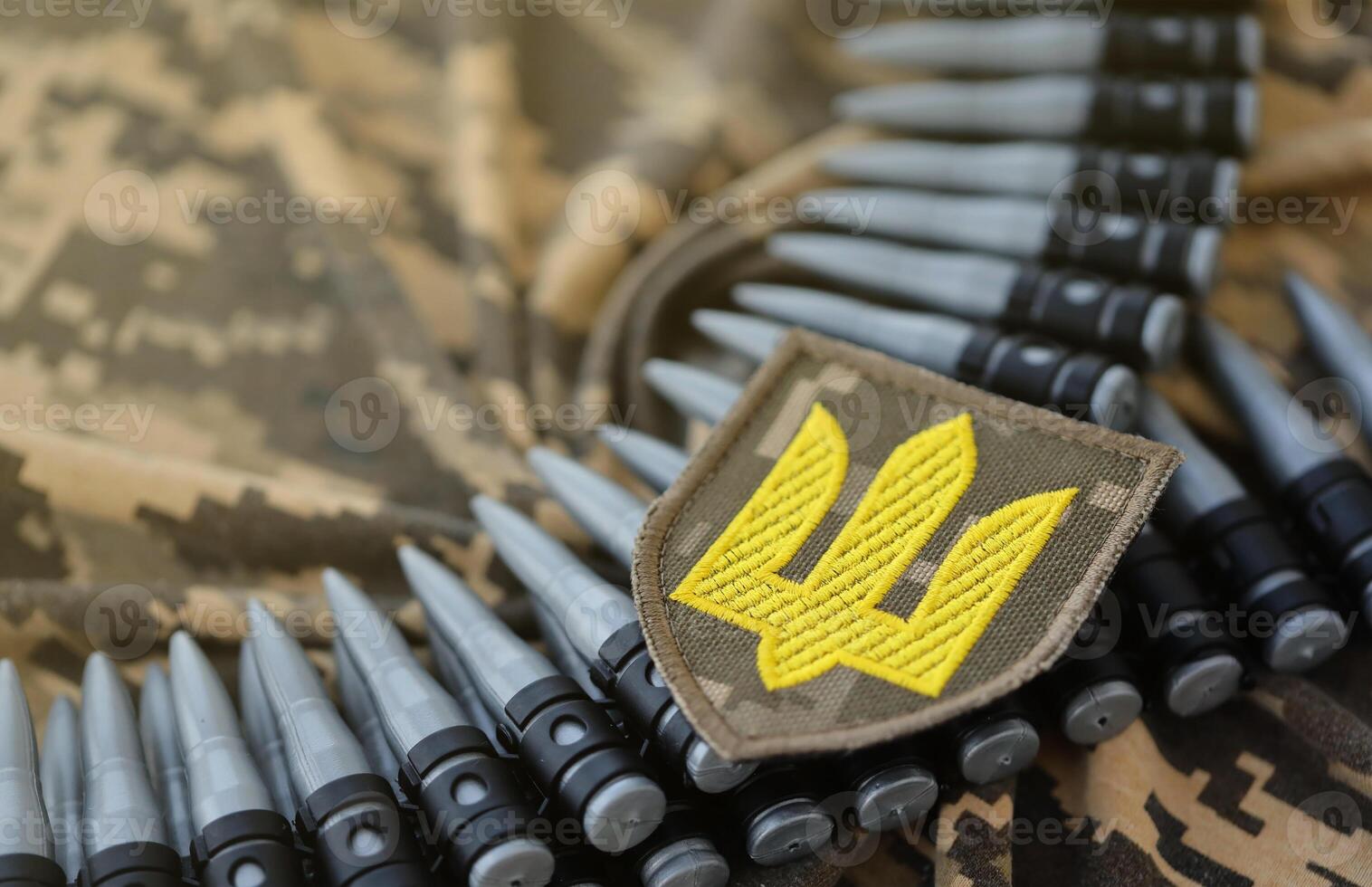 Ukrainian army symbol on machine gun belt lies on ukrainian pixeled military camouflage photo