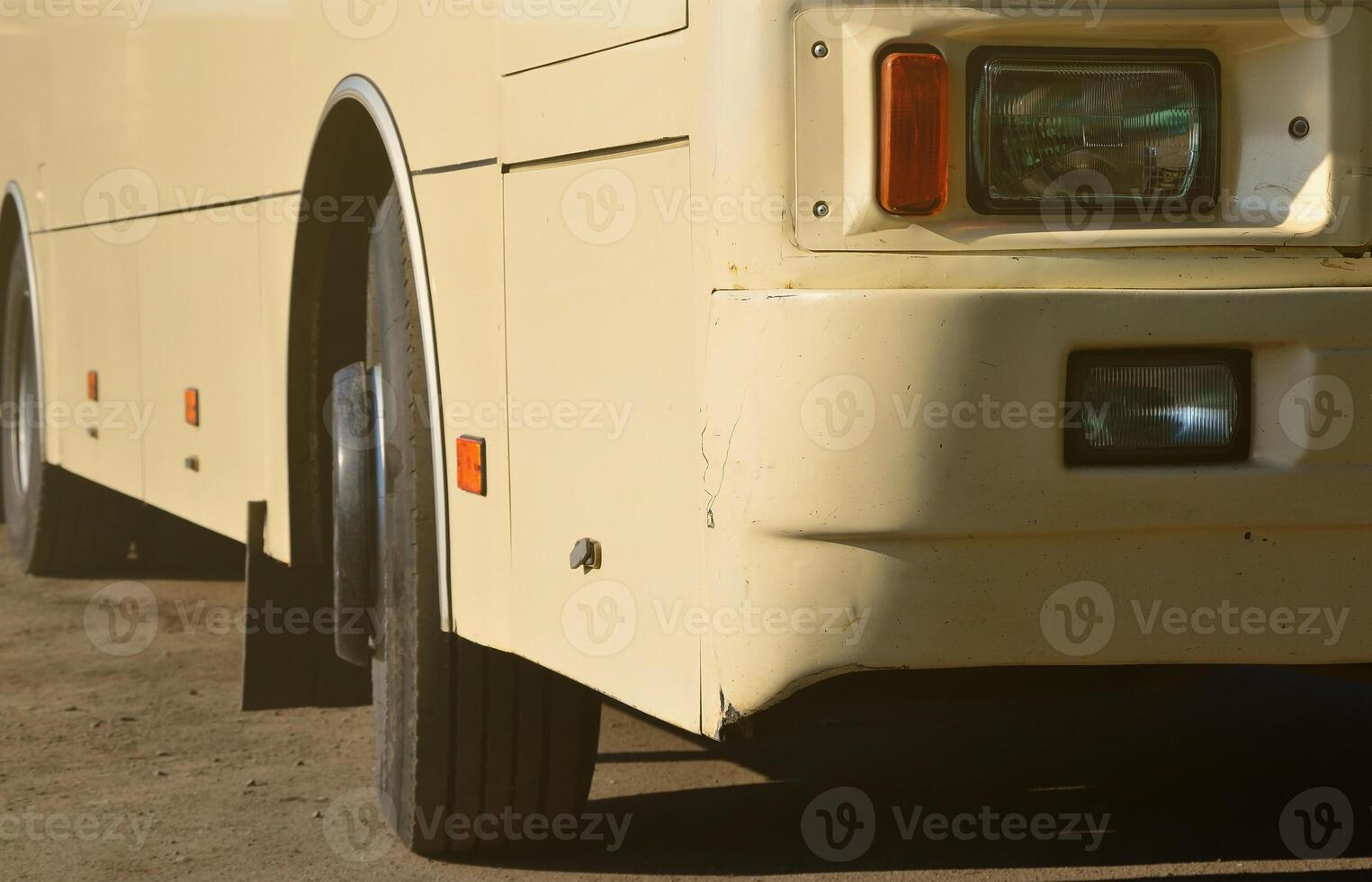 Photo of the hull of a large and long yellow bus. Close-up front view of a passenger vehicle for transportation and tourism