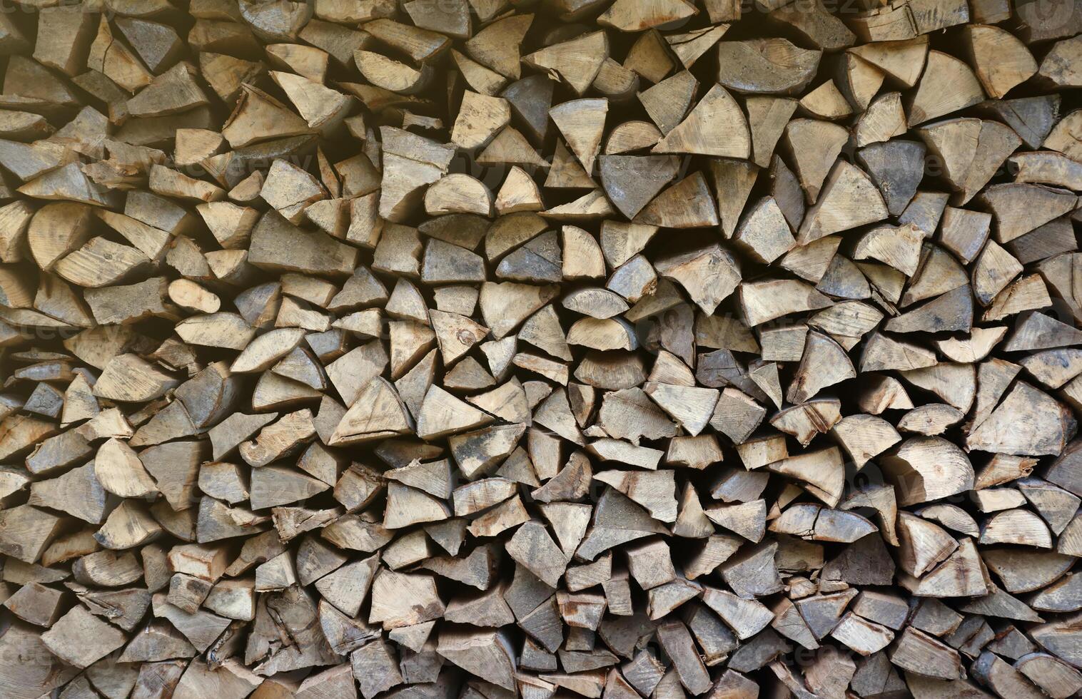 Firewood stacked near the wooden wall of old hut. Many chopped logs of firewood photo