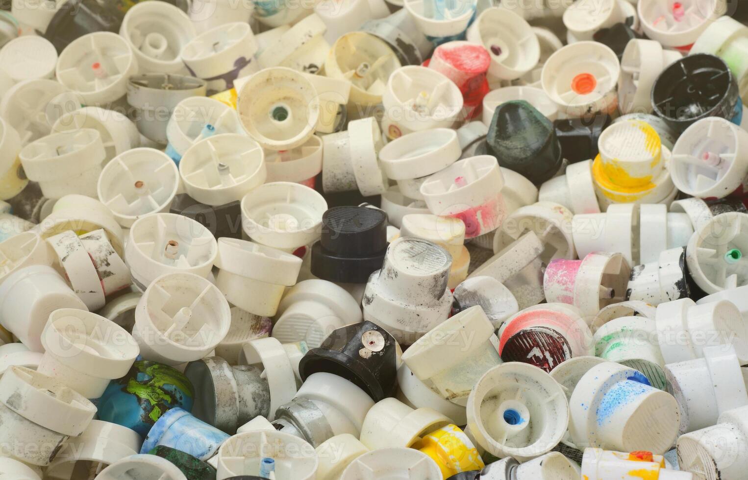 A pattern of many used and soiled nozzles from spray cans with aerosol paint. Background texture of the street art of drawing graffiti on the walls photo