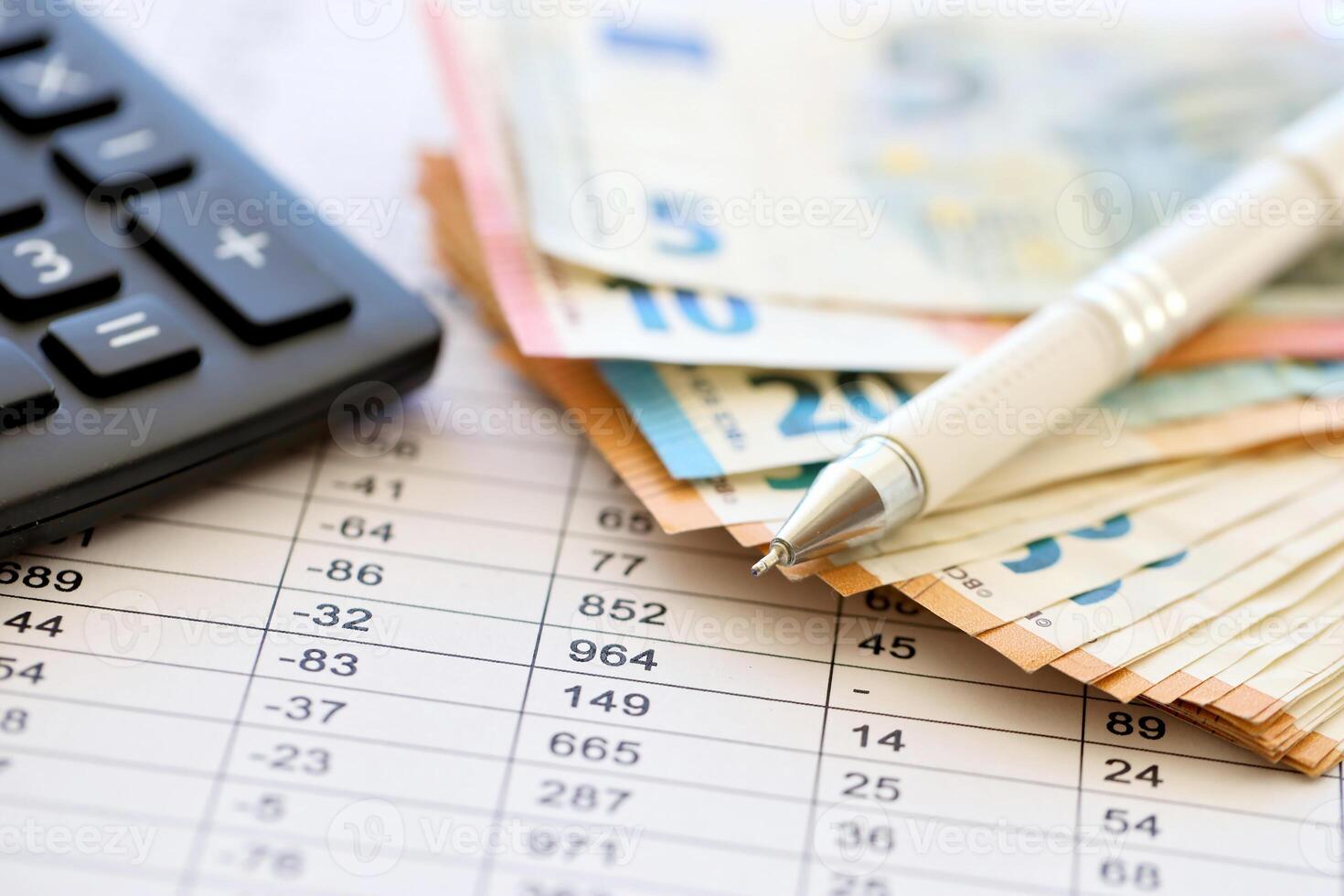 Business concept with many euro money bills, calculator and pen photo