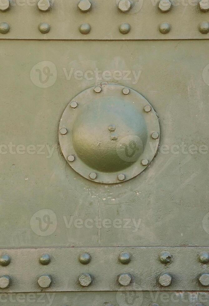 The texture of the wall of the tank, made of metal and reinforced with a multitude of bolts and rivets. Images of the covering of a combat vehicle from the Second World War photo