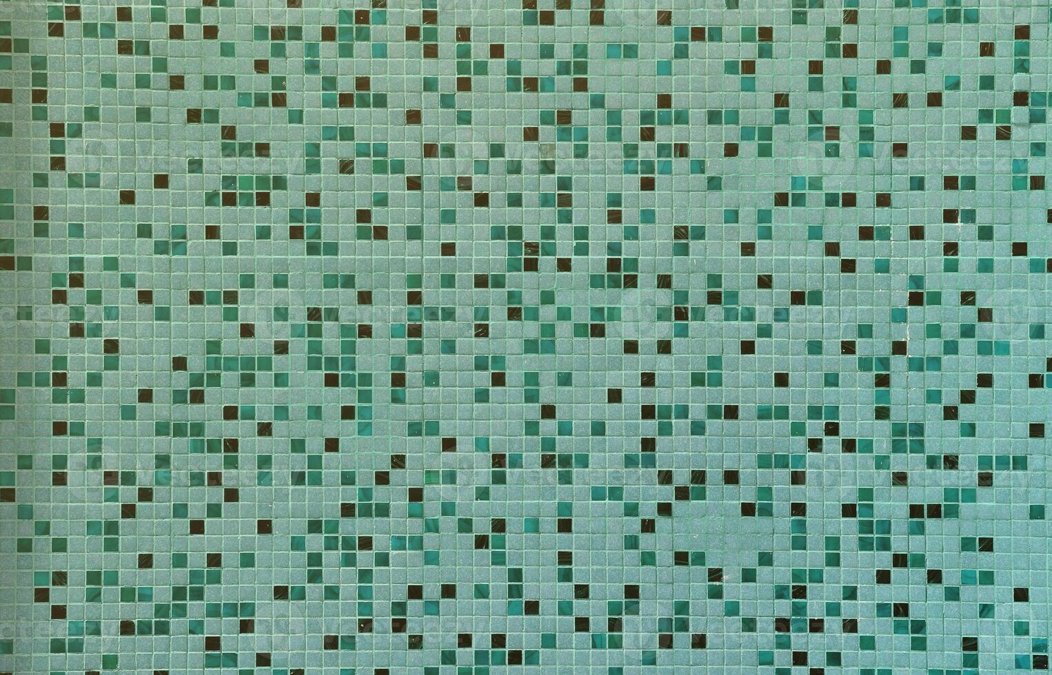 The texture of the wall, decorated with a mosaic of various small square tiles. Abstract pattern of ceramic tiles on the wall photo