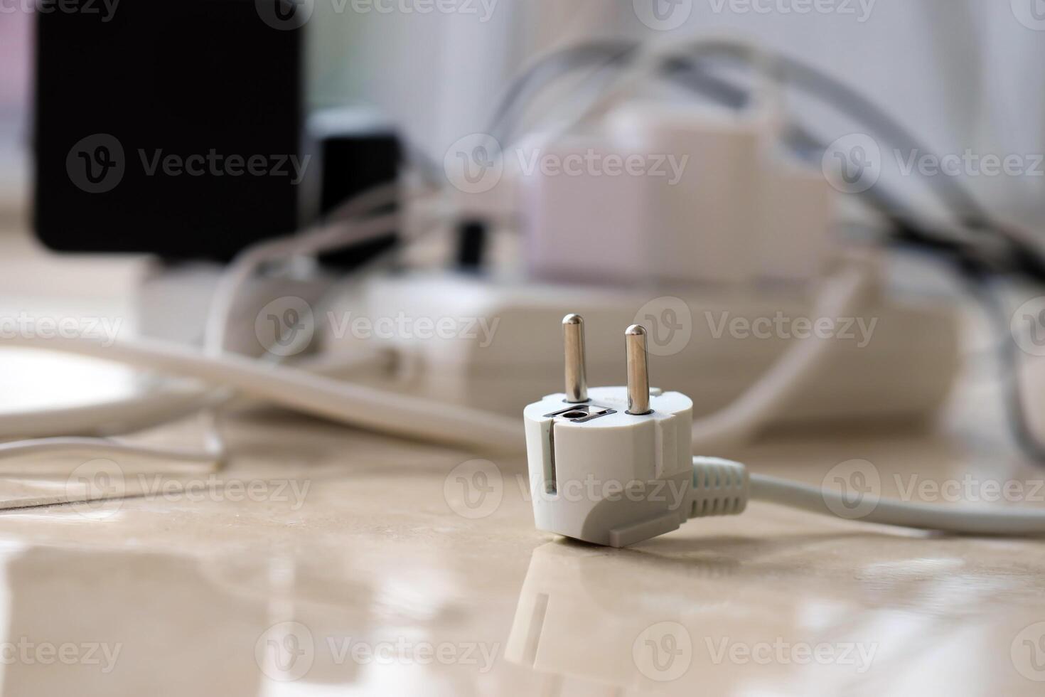Overloaded power boards. Power strips with different electrical plugs on white floor photo