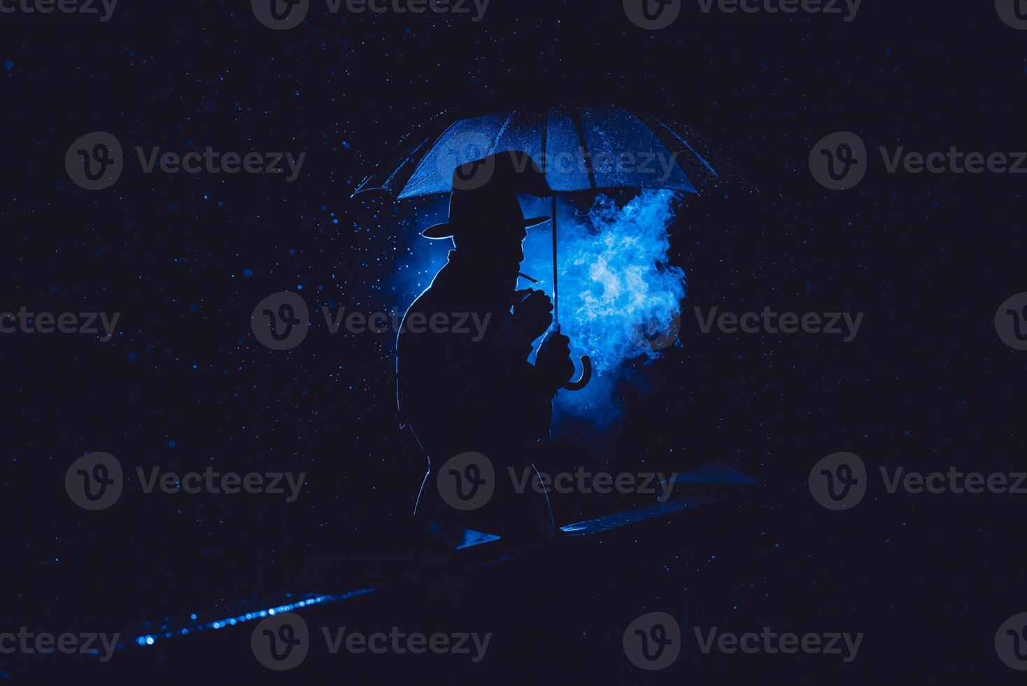 male detective in a hat and raincoat under an umbrella smokes at night photo