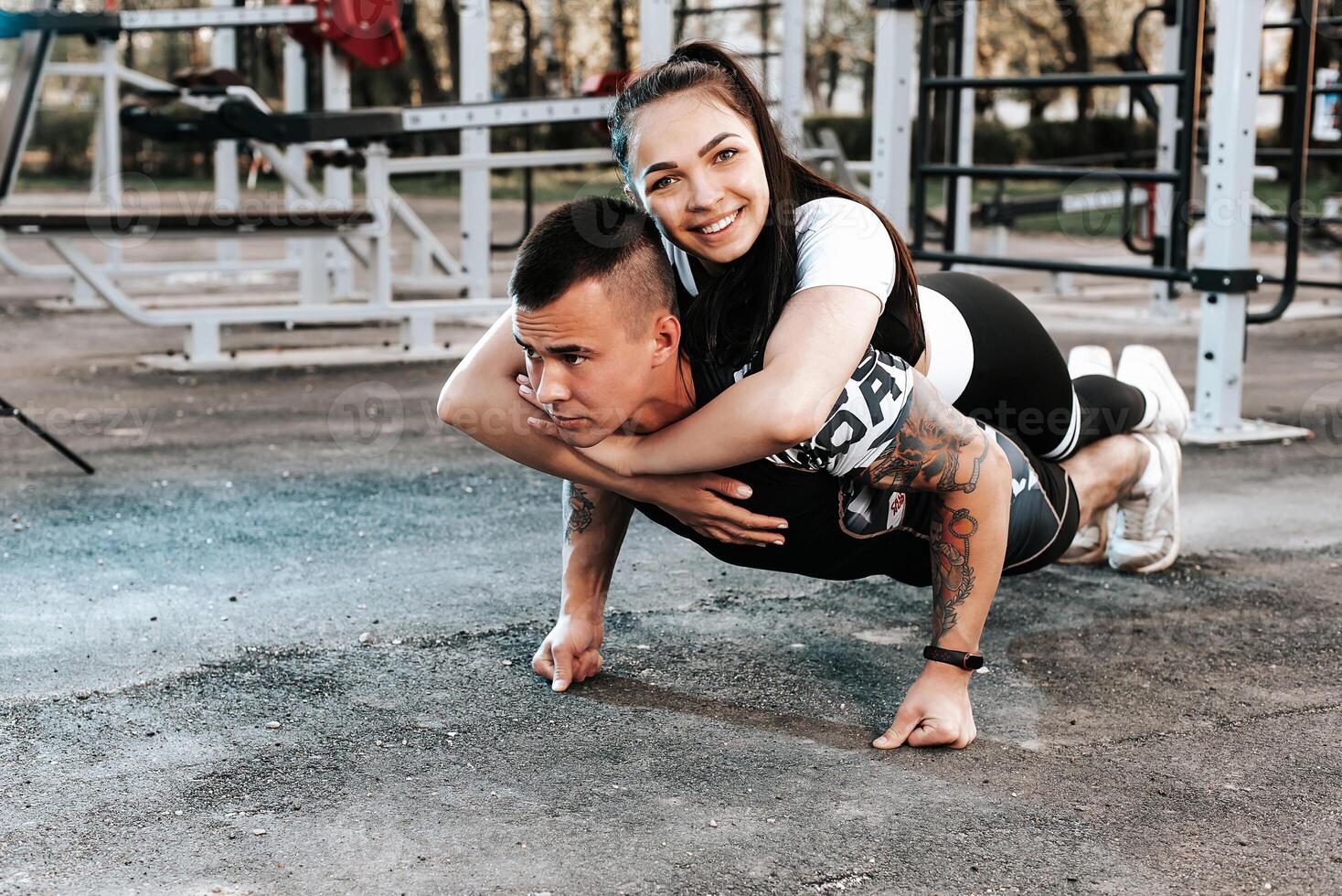 couple in love train together on the horizontal bars and play sports photo