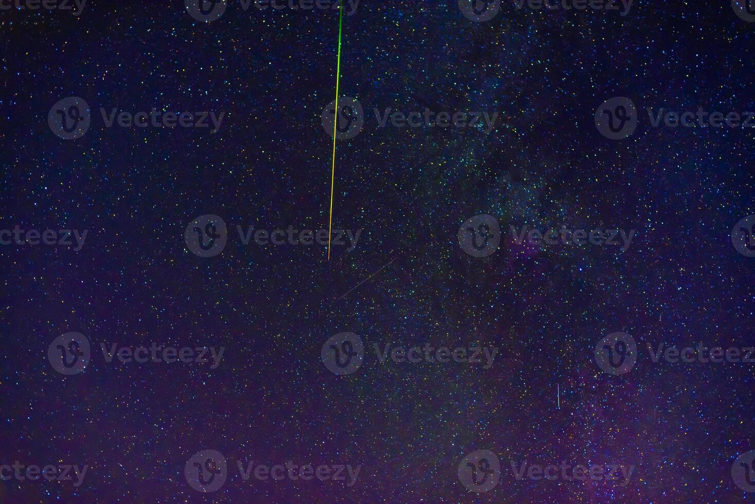 shooting star meteorite comet on background of blue dark starry sky with galaxies and nebulae photo
