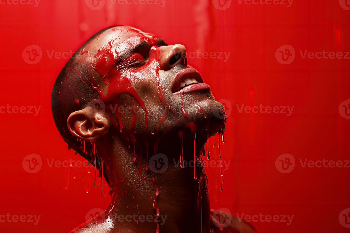 black upset man with red paint on his face is crying on a red background photo