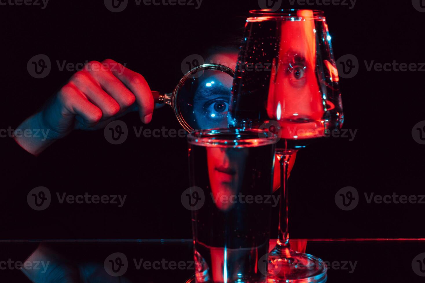surreal portrait of a man looking through a magnifying glass and glass glasses with water photo