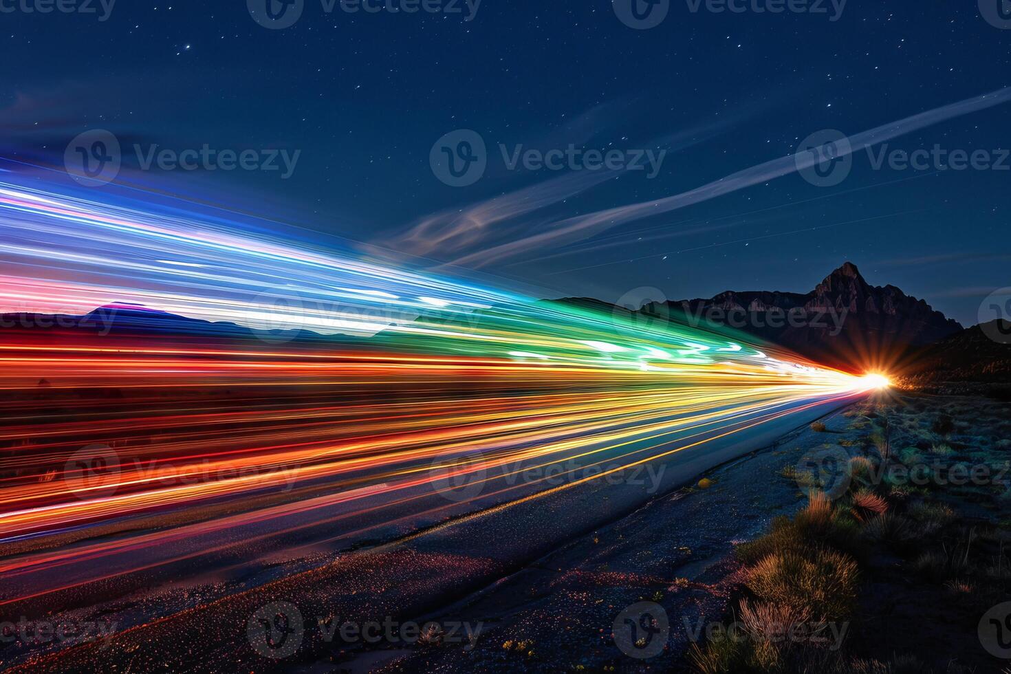 Rainbow-colored light trails transparently streaking across the night sky photo