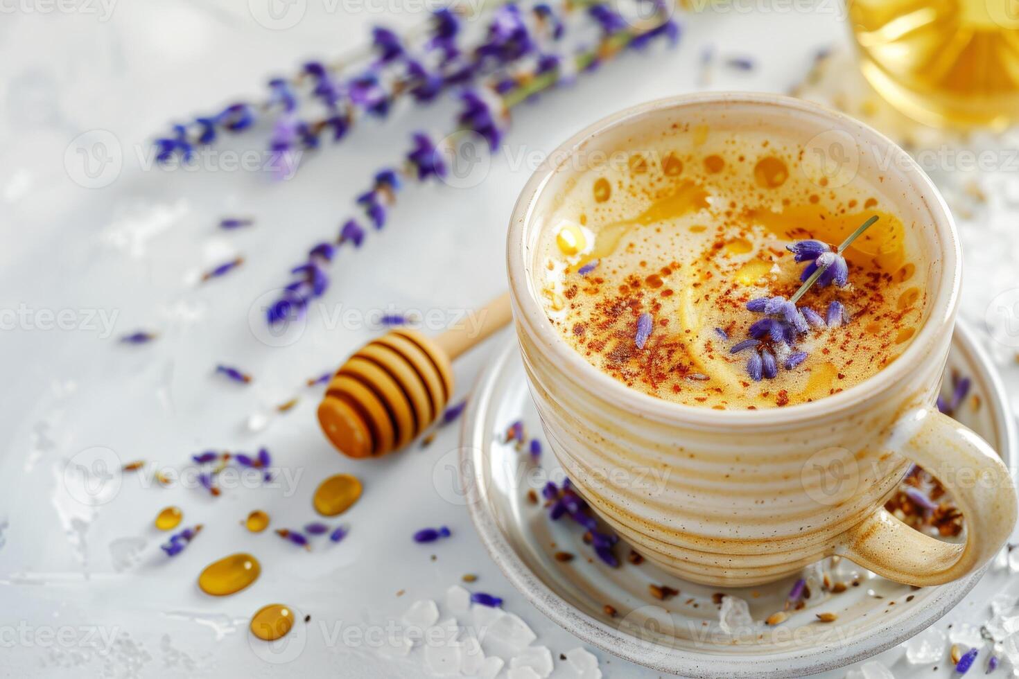 A cup of coffee with a spoon and a honey drizzle on top. The cup is on a white plate with lavender flowers photo
