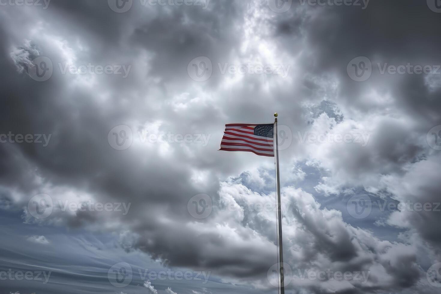 American flag on a pole against a cloudy sky photo