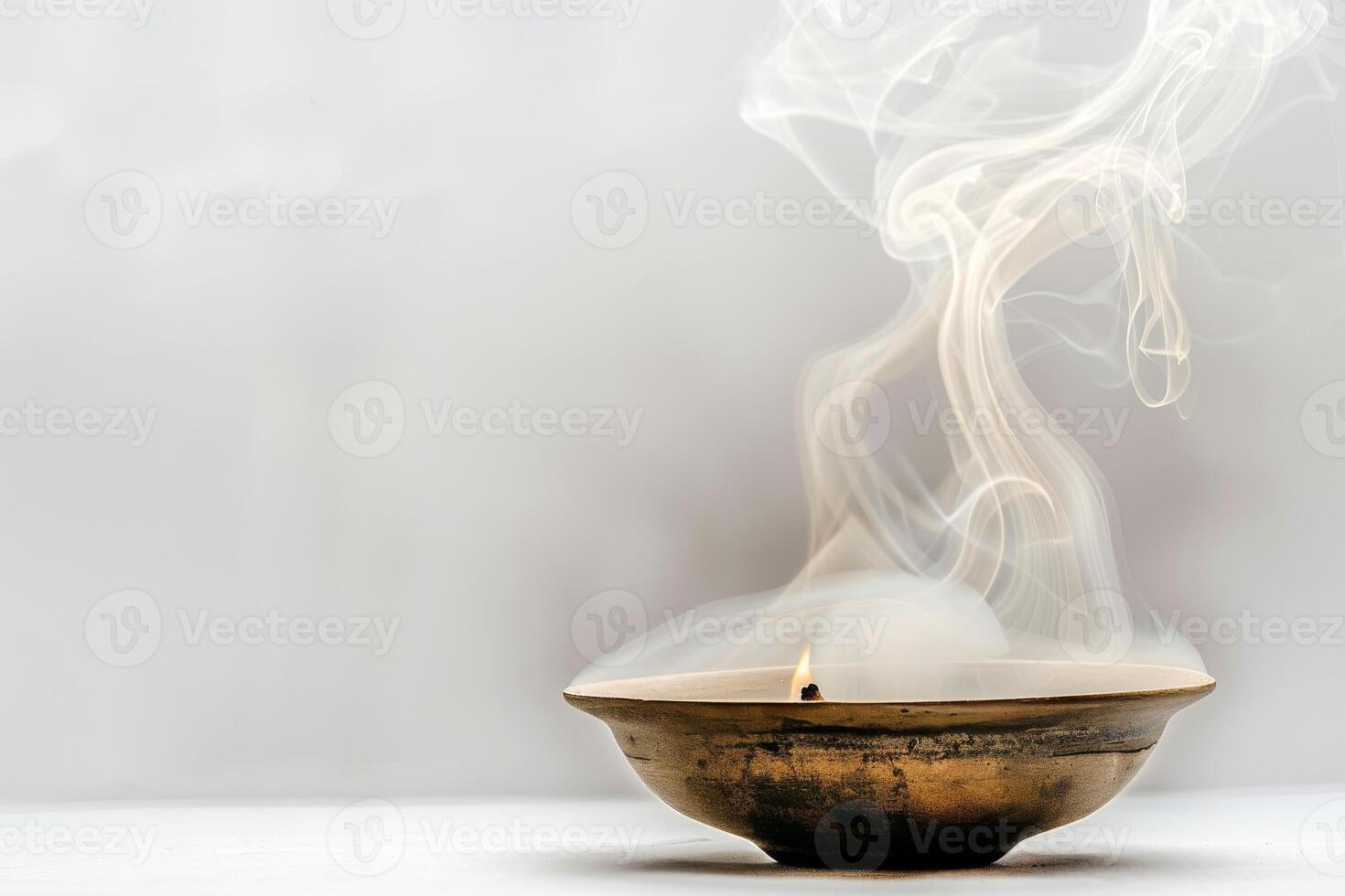 Burning incense releasing fragrant smoke against a soft transparent white background, ideal for spiritual and mystical themes photo
