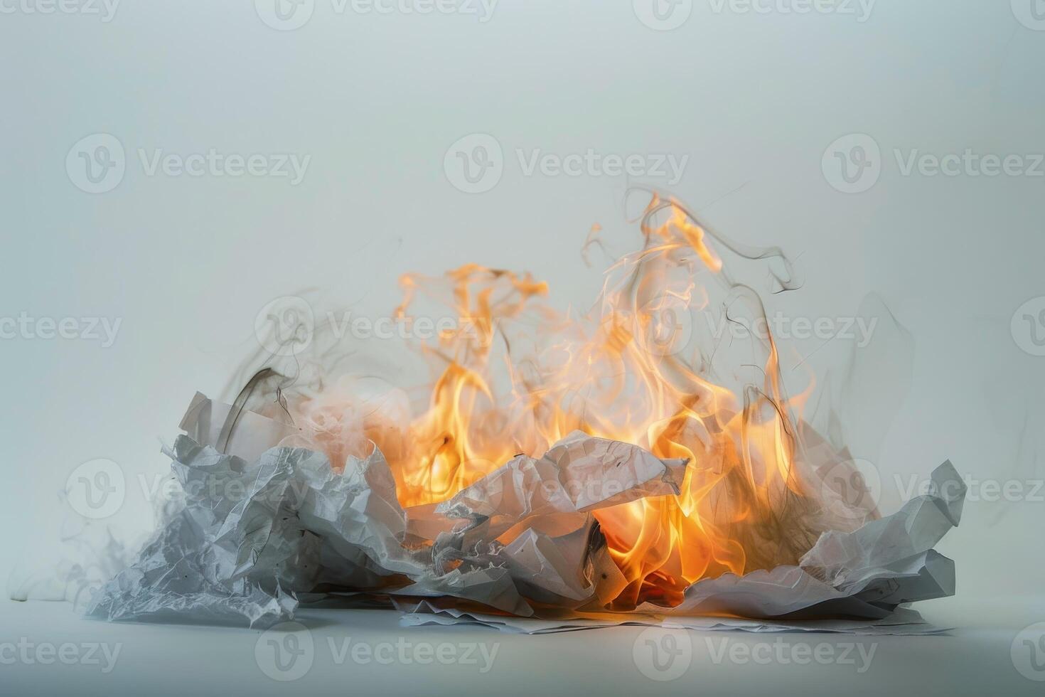 Burning paper engulfed in flames against a soft transparent white background, symbolizing destruction and transformation photo