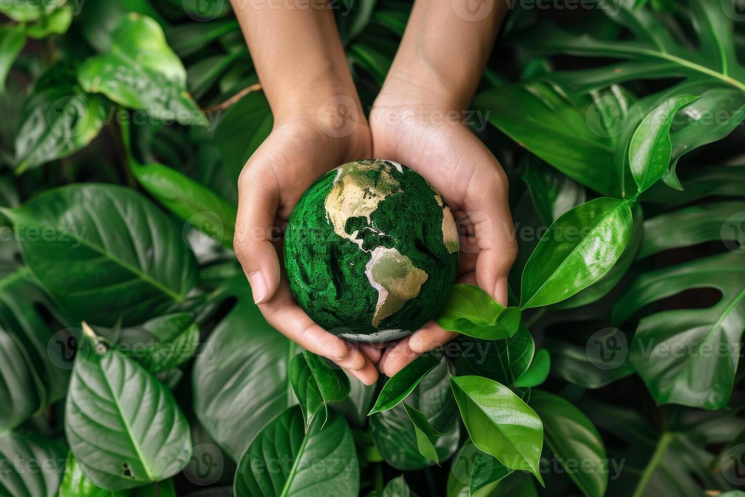 Hands holding a globe surrounded by leaves, representing global efforts for environmental conservation photo