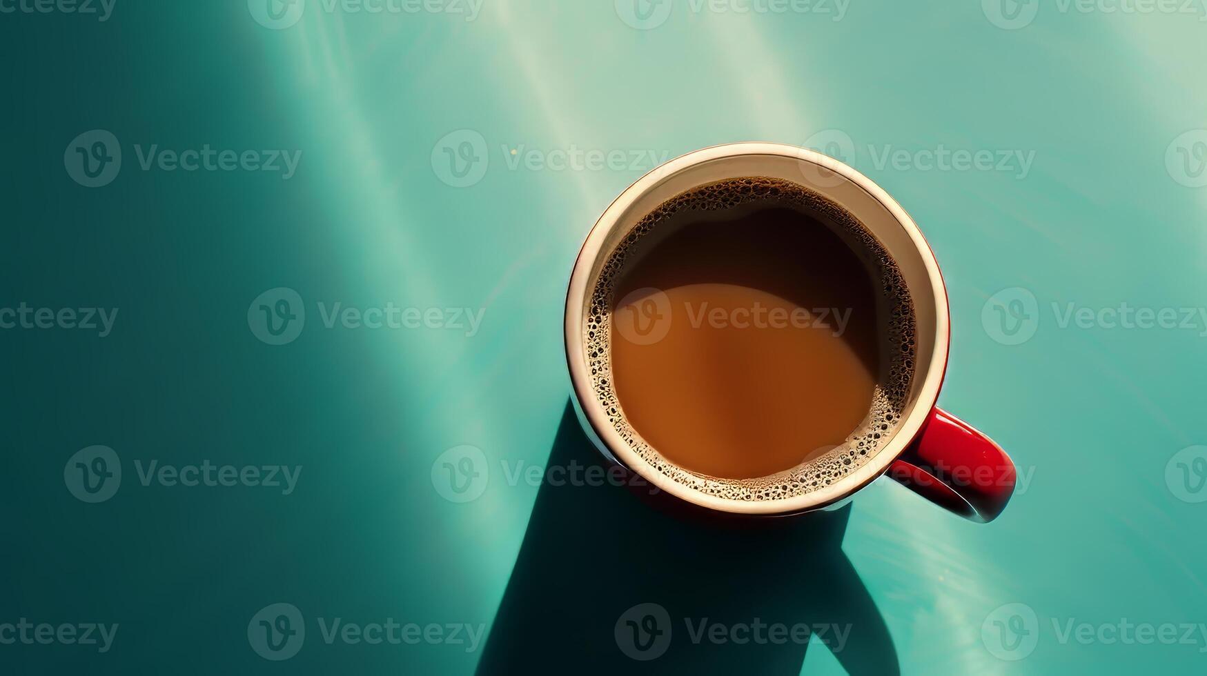 A red coffee cup with a brown liquid in it sits on a blue surface. The cup is half full, and the liquid appears to be a dark brown color. Concept of relaxation and comfort photo