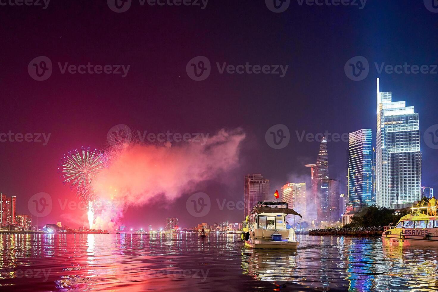 Celebration with fireworks light up sky over business district in Ho Chi Minh City, Vietnam. Beautiful night view cityscape. Holidays, independence day, New Year and Tet holiday photo