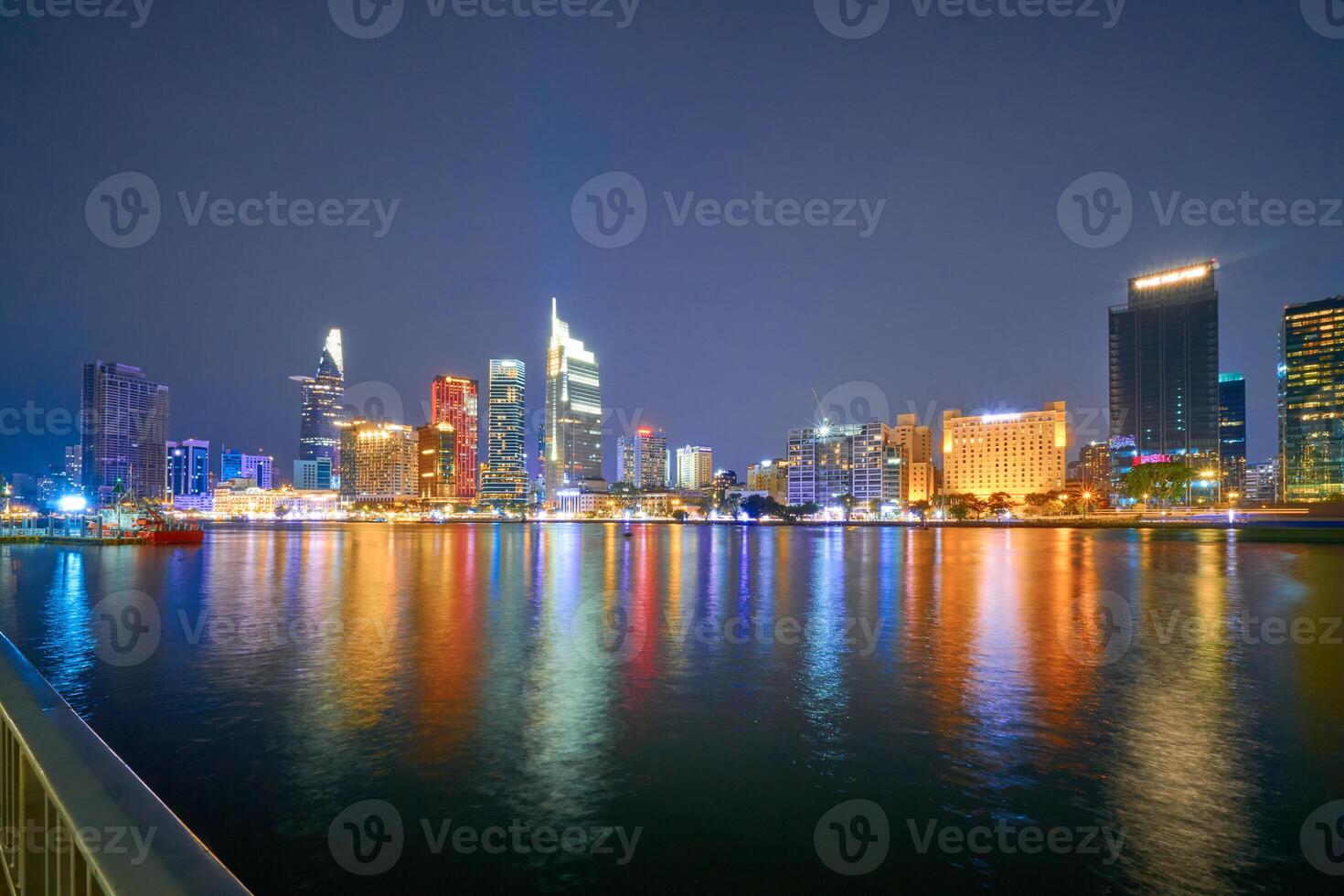 Ho Chi Minh City skyline and the Saigon River. Amazing colorful night view of skyscraper and other modern buildings at downtown. Travel concept photo