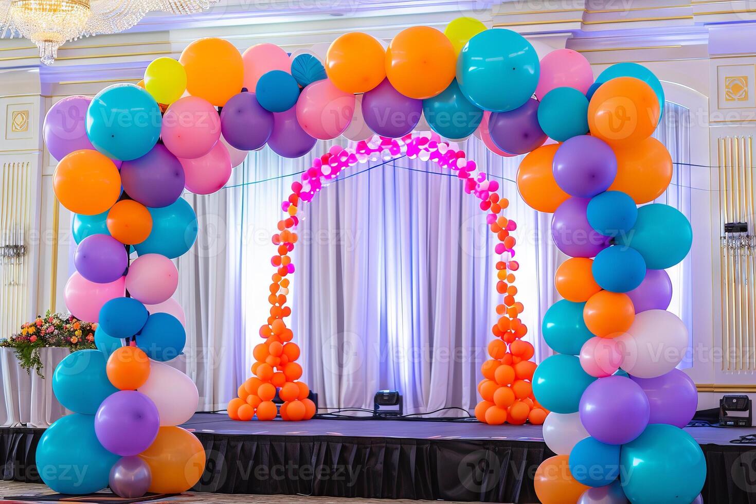 Colorful balloon arch framing a stage at a charity event, creating a festive backdrop photo